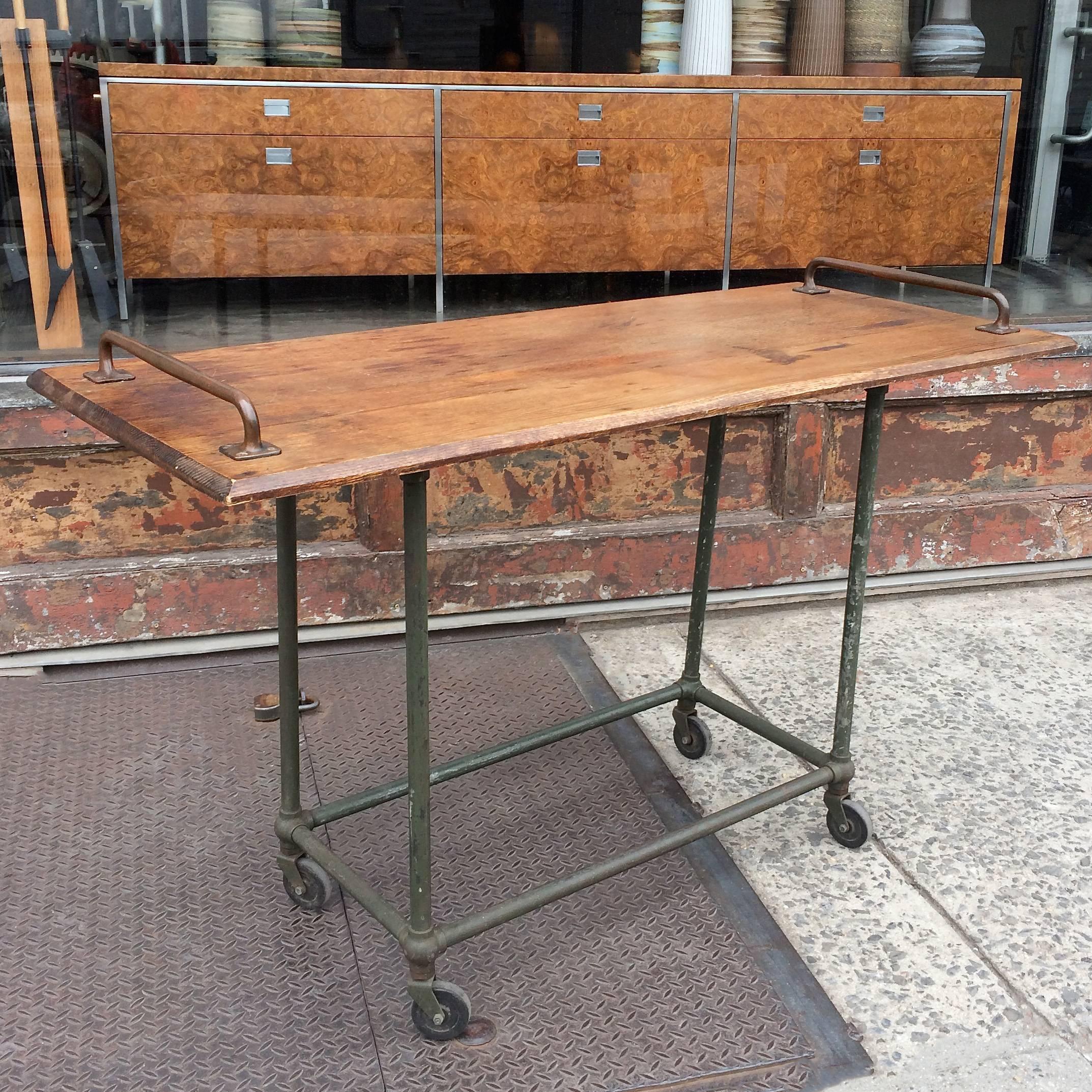 Custom, Industrial, console table features a reclaimed oak top with beveled edge, brass handle accents and a painted steel, rolling base. The table works well as a tall dining table or kitchen island as well as a work table or console. The angle