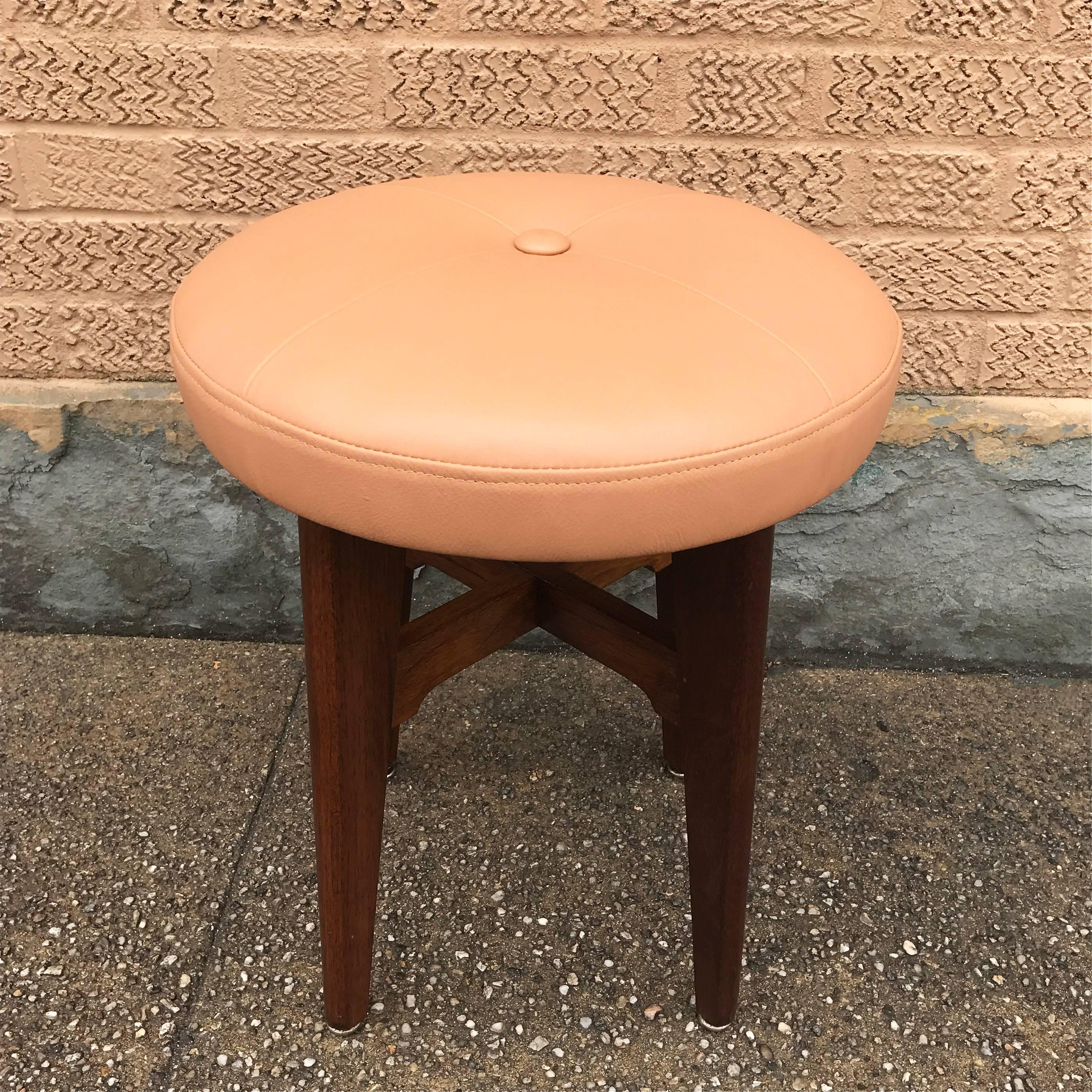Mid-Century Modern vanity stool features a walnut base and peach leather upholstered seat.