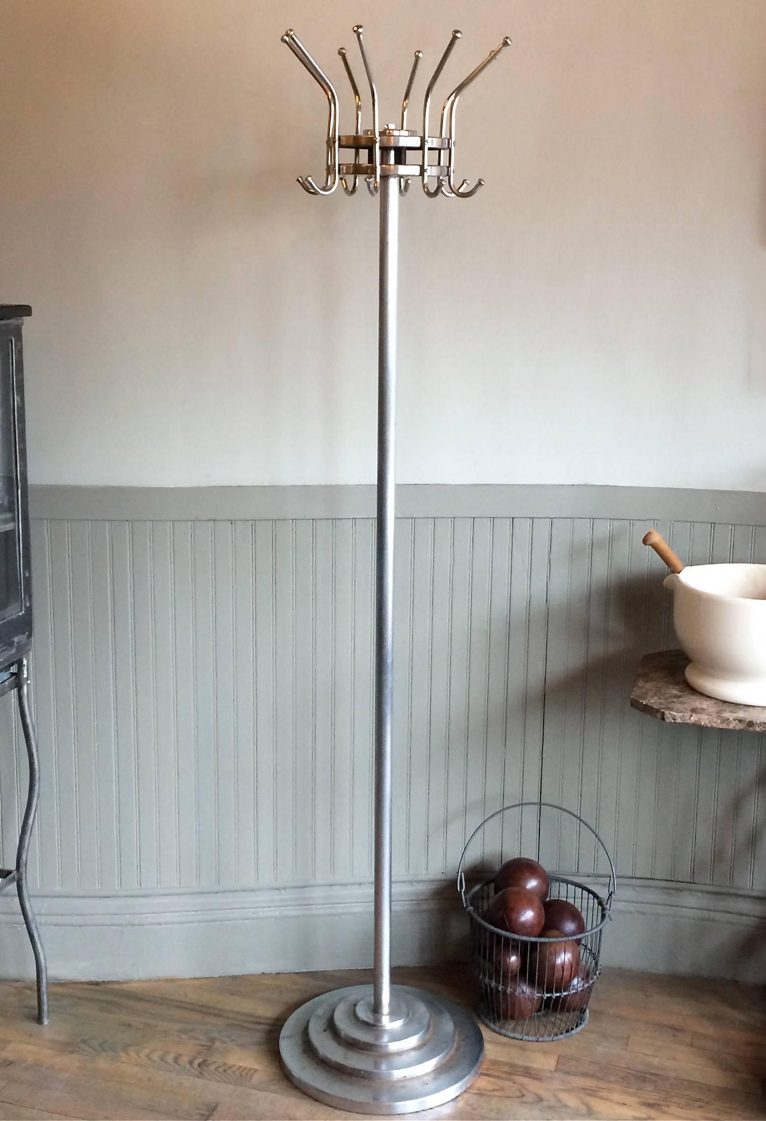Vintage, American, Art Deco, machine age, freestanding hat or coat rack features a chrome-plated tubular steel post, weighted by a decorative cast iron stepped base with a revolving, detachable, oversized, double hook rack. Overall good condition