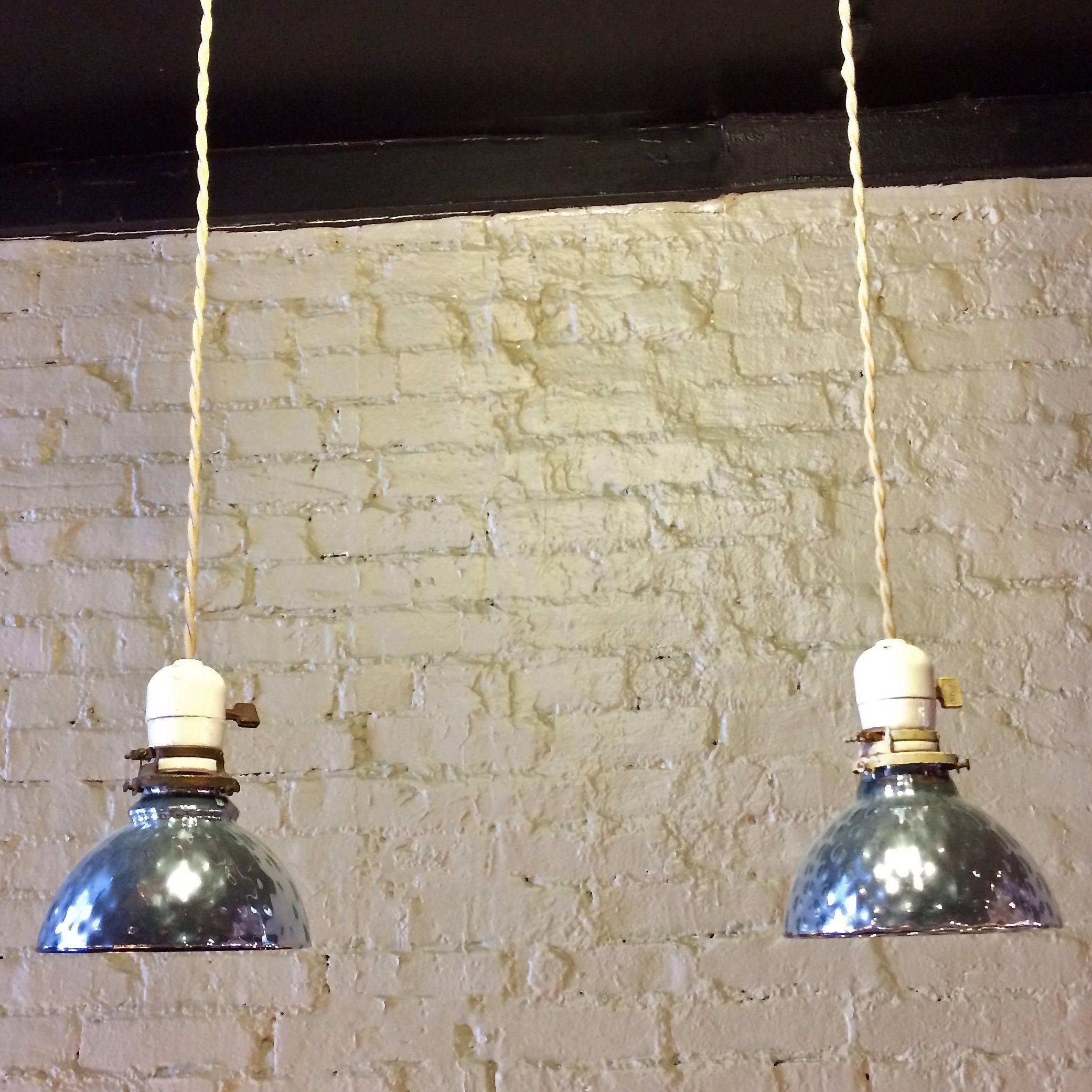 Pair of Industrial, light blue, quilted, blown, mercury glass, bell shape pendant lights with early porcelain and brass fitters with paddle switches are newly wired with 40