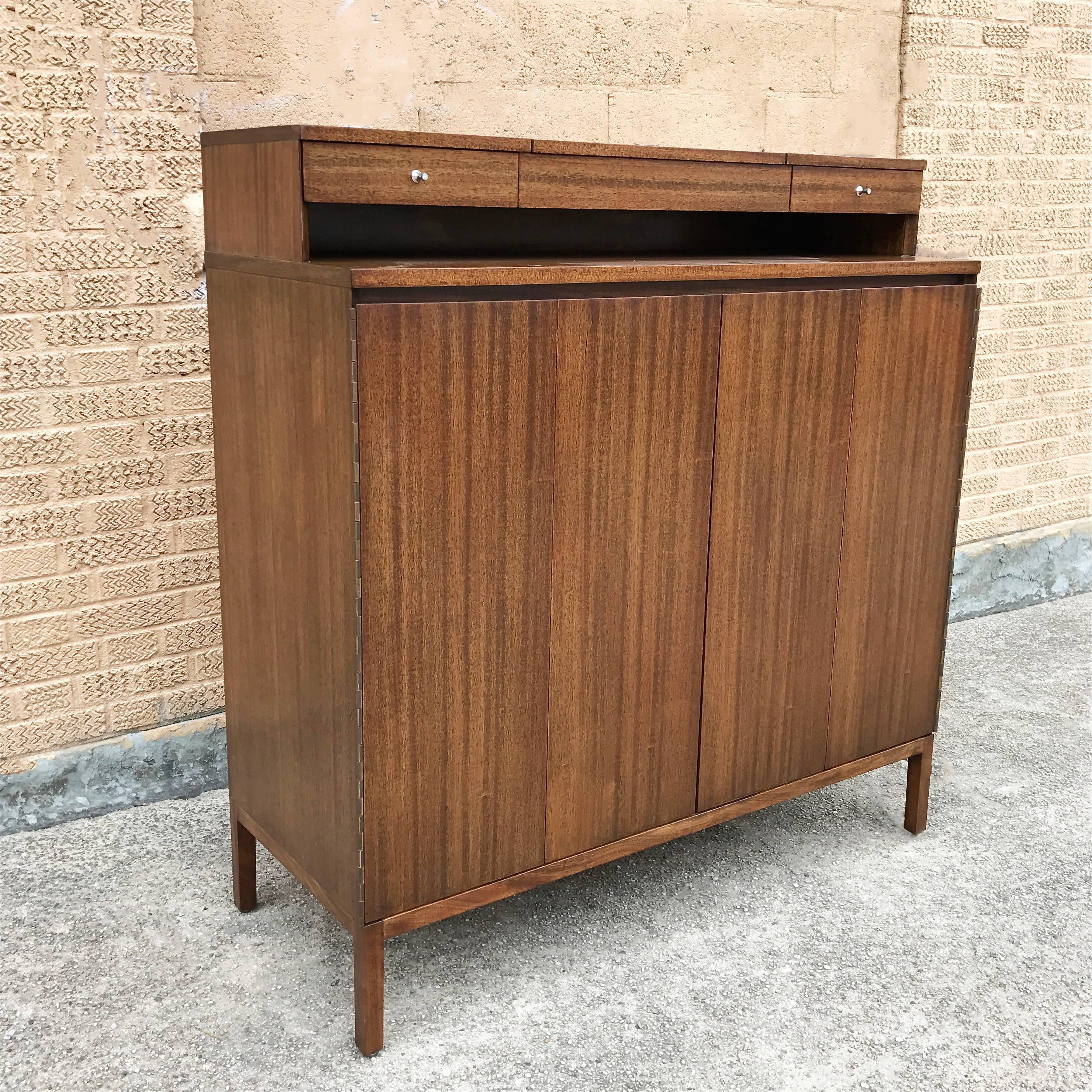 Mid-Century Modern, walnut, gentleman's chest, highboy dresser by Paul McCobb for Calvin, The Irwin Collection features multiple hidden drawers and shelves, a pop-up vanity mirror with an electric outlet underneath it.