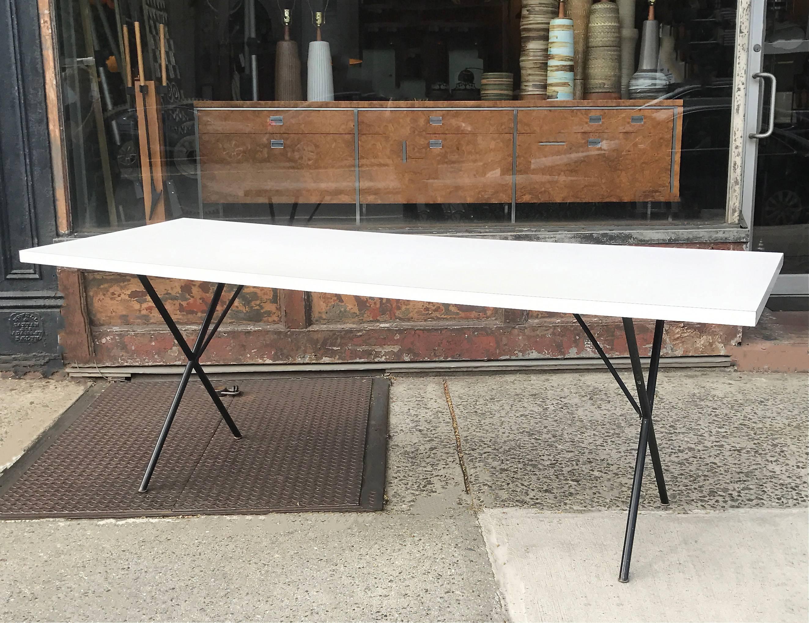 Mid-Century Modern, long, dining or work table designed by George Nelson for Herman Miller features a white laminate top with painted black iron 