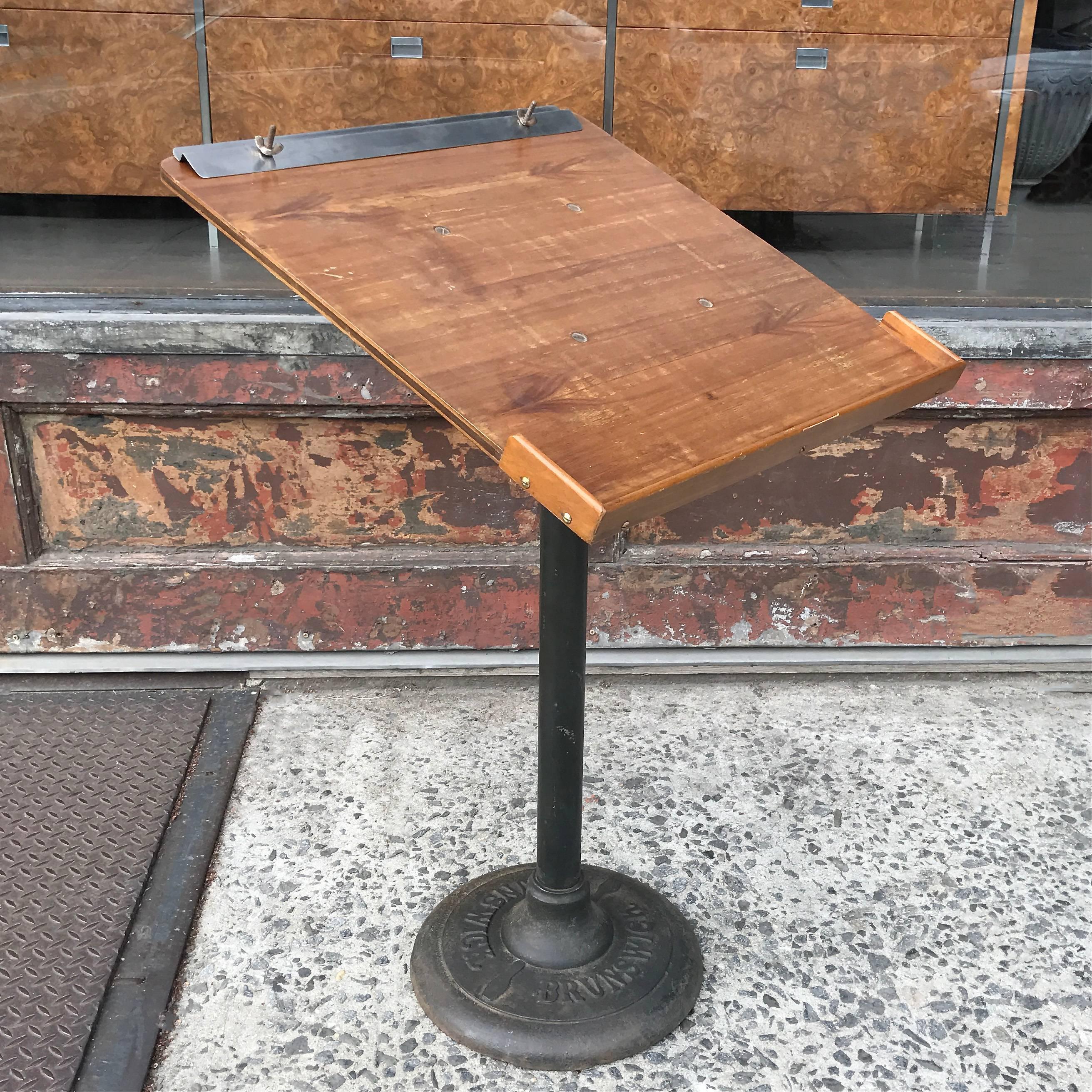 Industrial, 1940s bowling score stand by Brunswick with wood top and cast iron base.
  