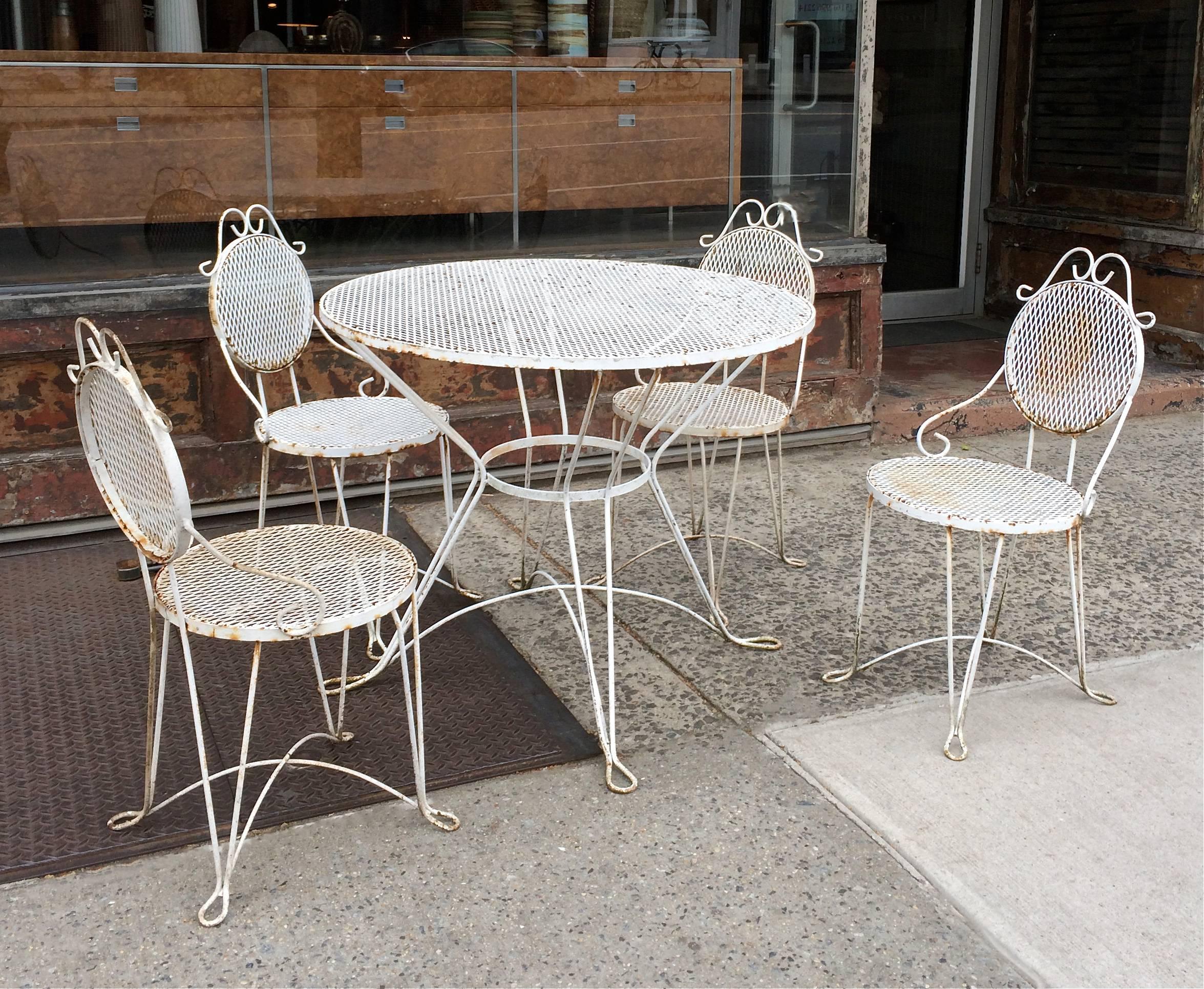Mid-Century, painted wrought iron and mesh, patio, outdoor dining set features a round table and four chairs in original vintage condition.

Table: 36