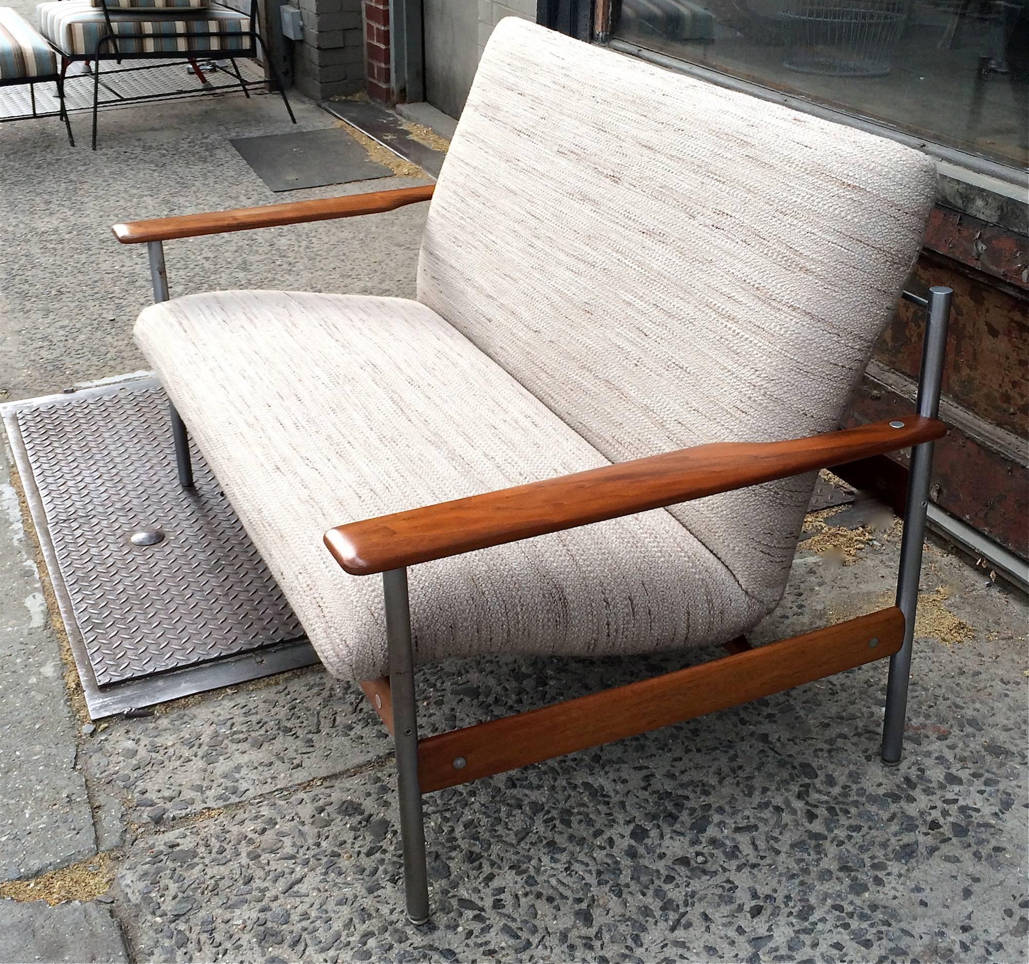 Scandinavian modern loveseat sofa Model 1001 designed by Sven Ivar Dysthe in 1959, Norway features a walnut and tubular stainless steel frame and is newly upholstered in a wheat colored, woven, cotton blend.