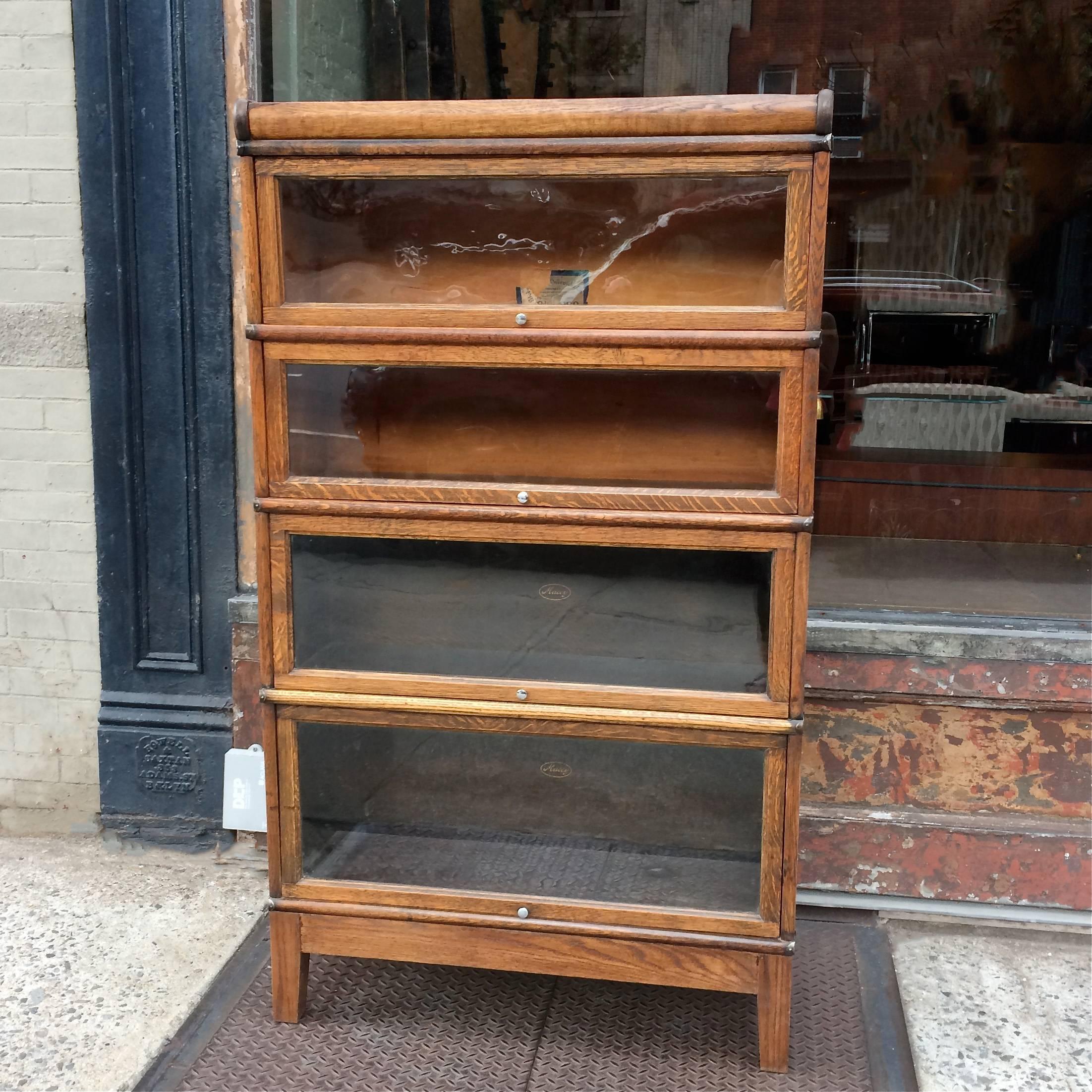 Early 20th century, four-stack, sectional bookcase, barrister case by The Globe Wernicke Co. is interlocking stacks of oak with glass fronts and steel scissor hinges, circa 1920s.

Macey stickers are from manufacturer The Macey Co. which merged