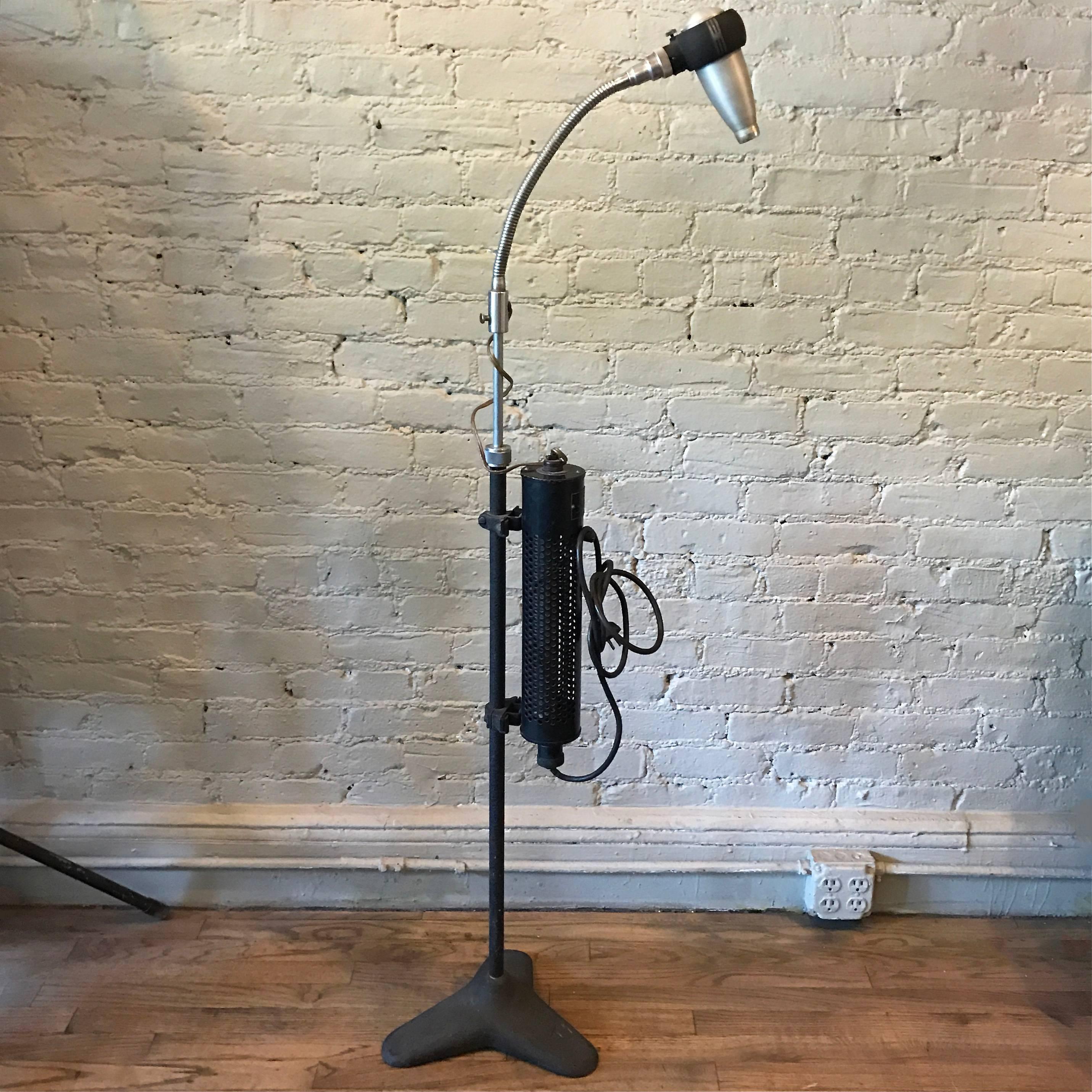 Industrial, machine age, optical, medical floor lamp by Bausch & Lomb features a cast iron base with height adjustable, gooseneck steel head that casts a focused light.