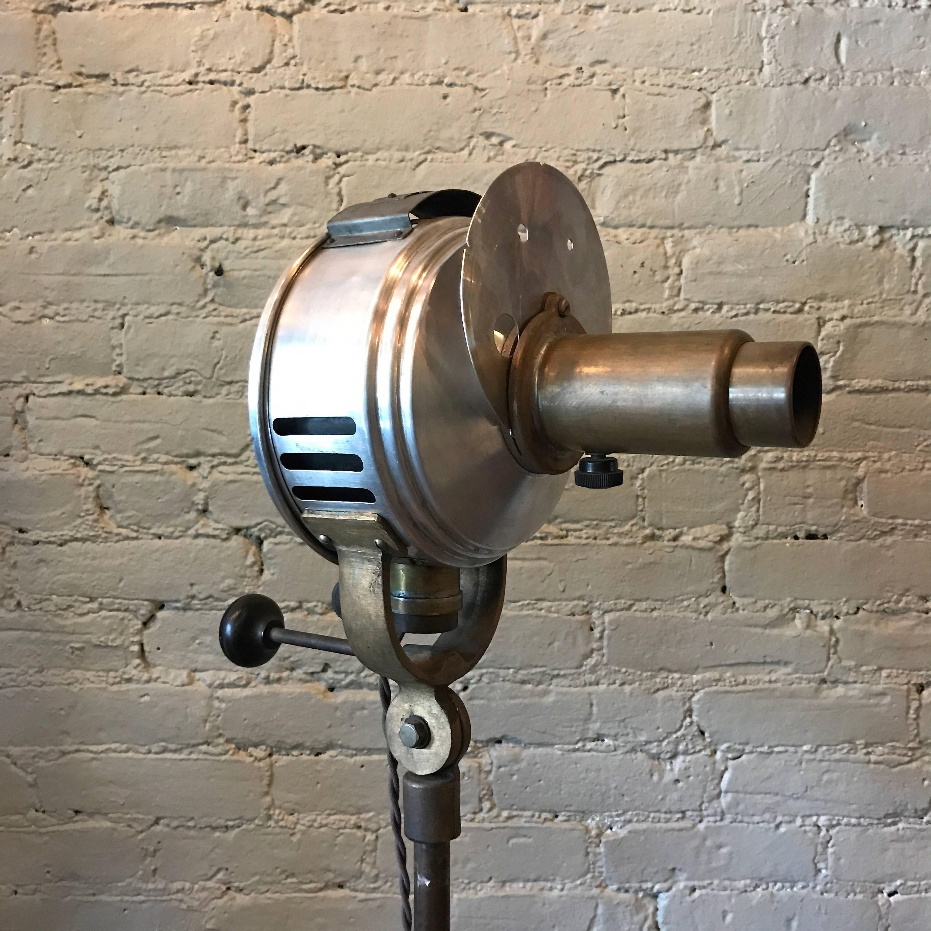 Industrial, machine age, medical, optical, floor lamp features a brass and steel head with cast iron base manufactured by Prometheus Electric Corp., New York is height adjustable 48 in - 64 in, articulating and casts a focused pin spot light.

   