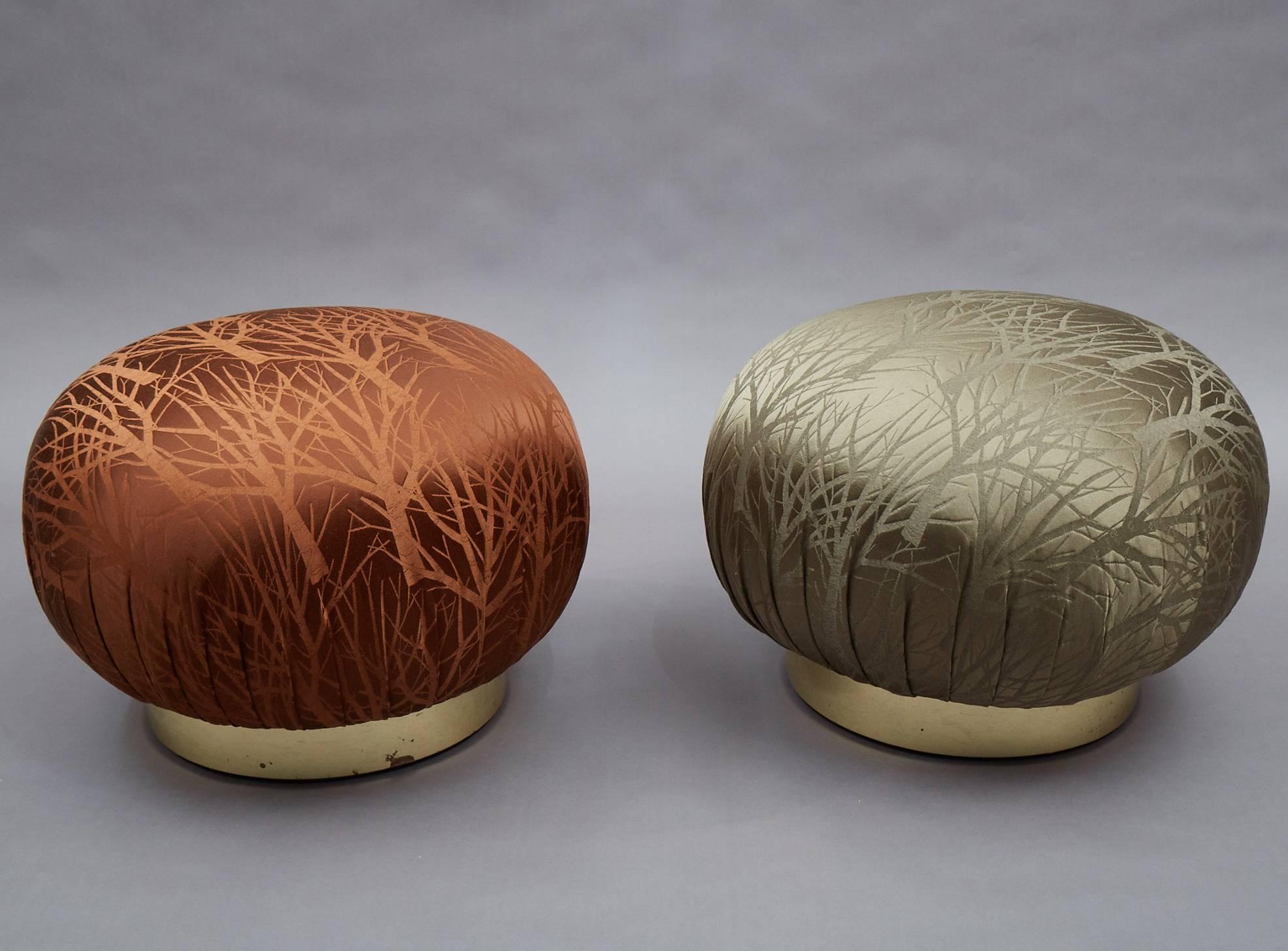 Pair of round, souffle pouf ottomans in the manner of Karl Springer feature newly upholstered seats in contrasting rust and moss, branch motif jacquard that swivel on brass bases.
