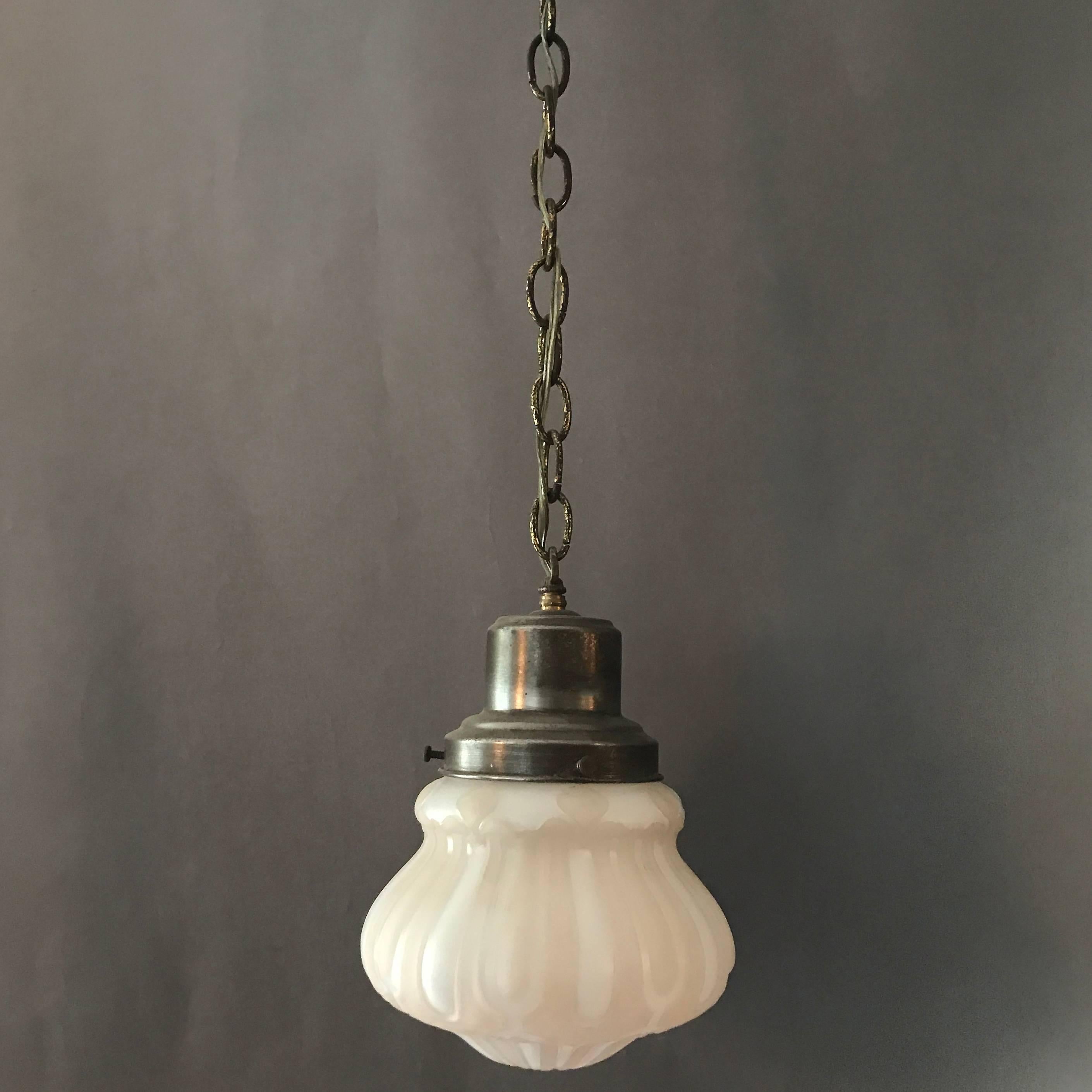 1930s, Industrial, Art Deco, library pendant light features a blush pink and white, painted, pressed glass shade with brass fitter, chain and canopy. Overall height is 28 in.