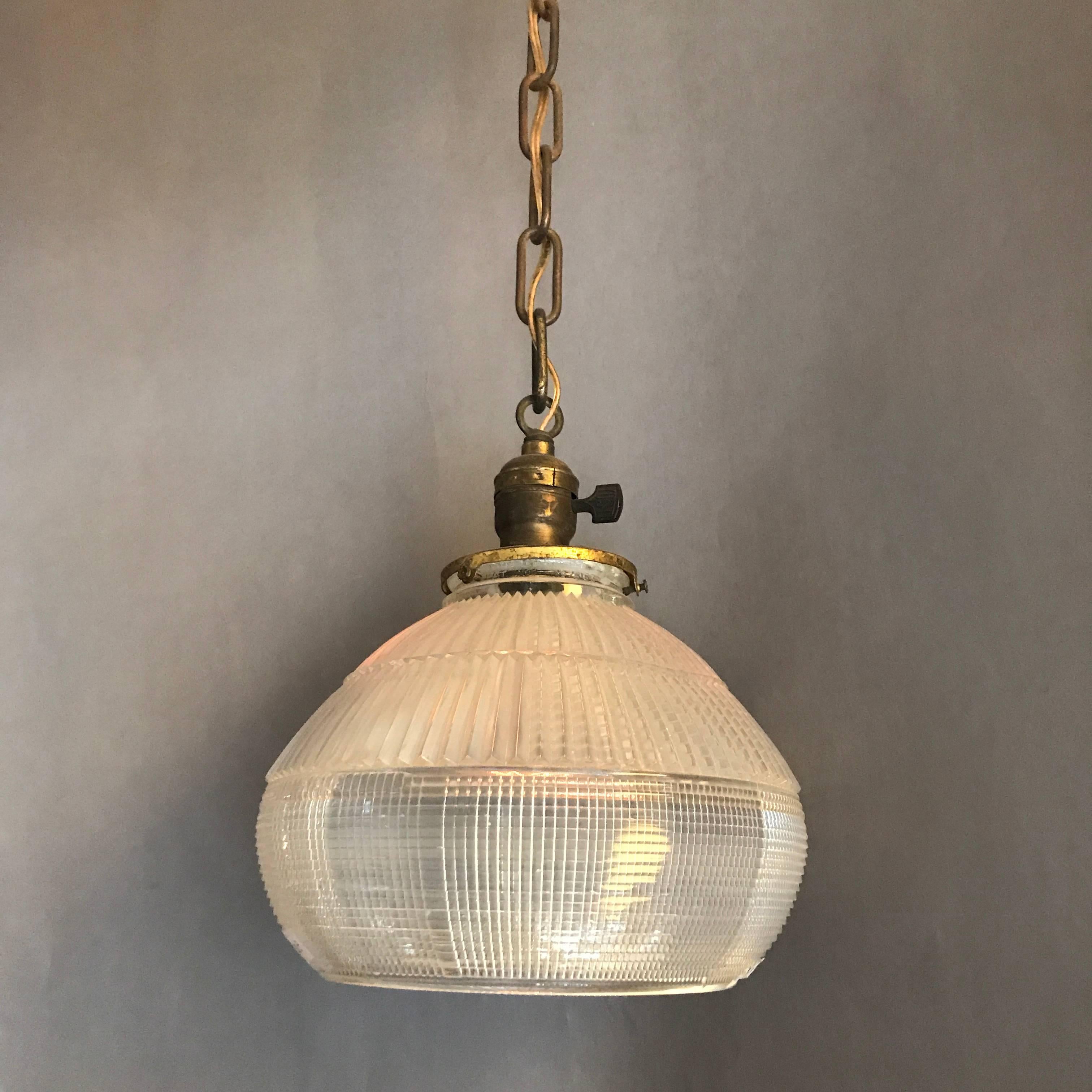 Industrial, factory, pendant light features prismatic, Holophane glass shades with brass fitter. The pendant is newly wired for 200 watts.

Overall height 32in. ht.