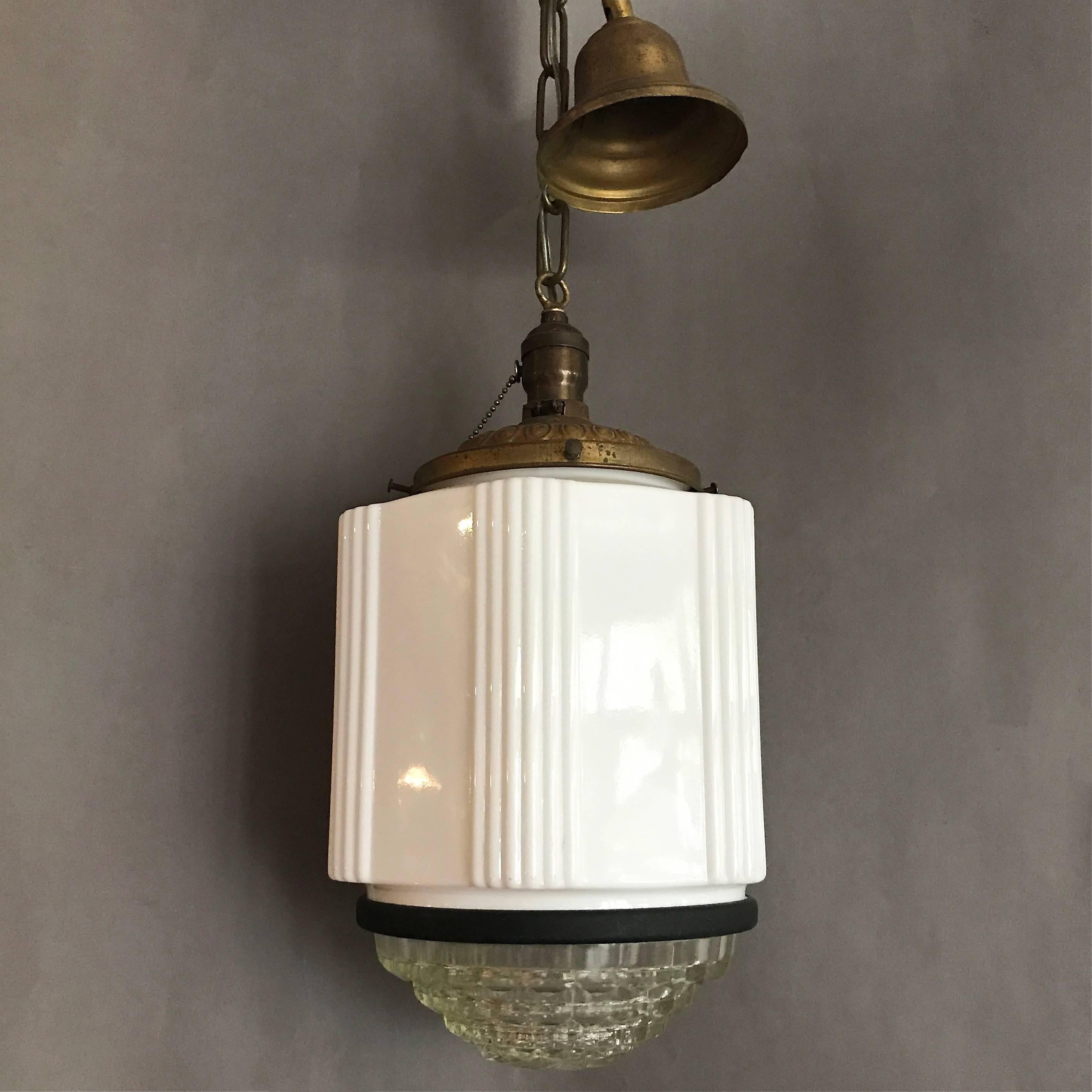 Art Deco, milk glass pendant has six sides with clear glass lens and brass hardware.

Measures: Overall height: 44in height.