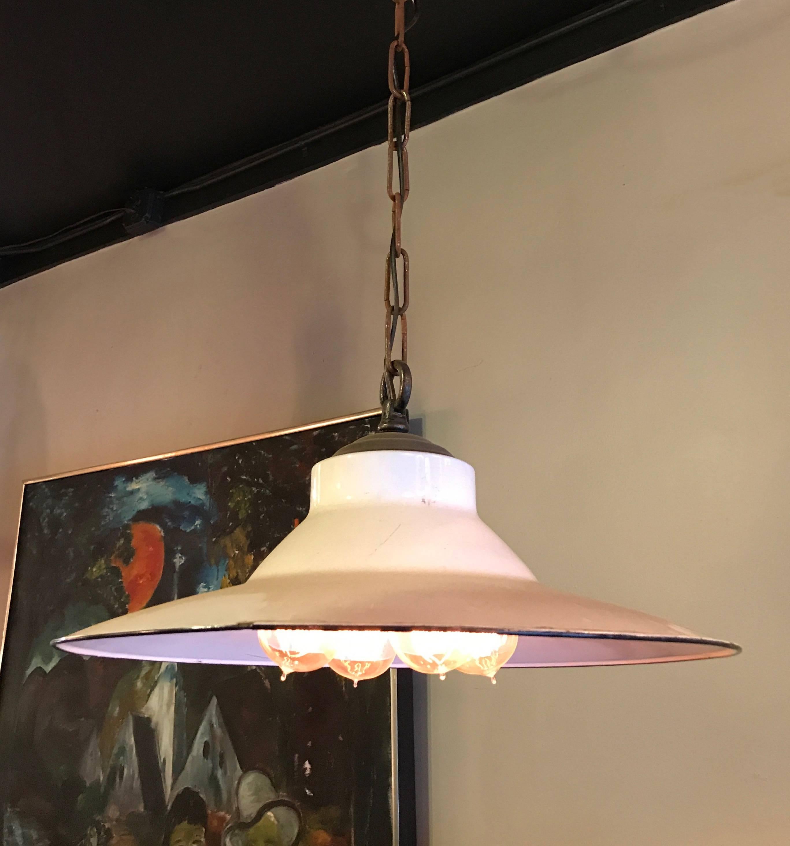Original, 1930s, Industrial, machine shop, pendant light features a white enameled steel shade with brass and porcelain, four-bulb, Benjamin socket and metal chain and canopy is newly wired to accept up to 400 watts total. Measures: Overall height
