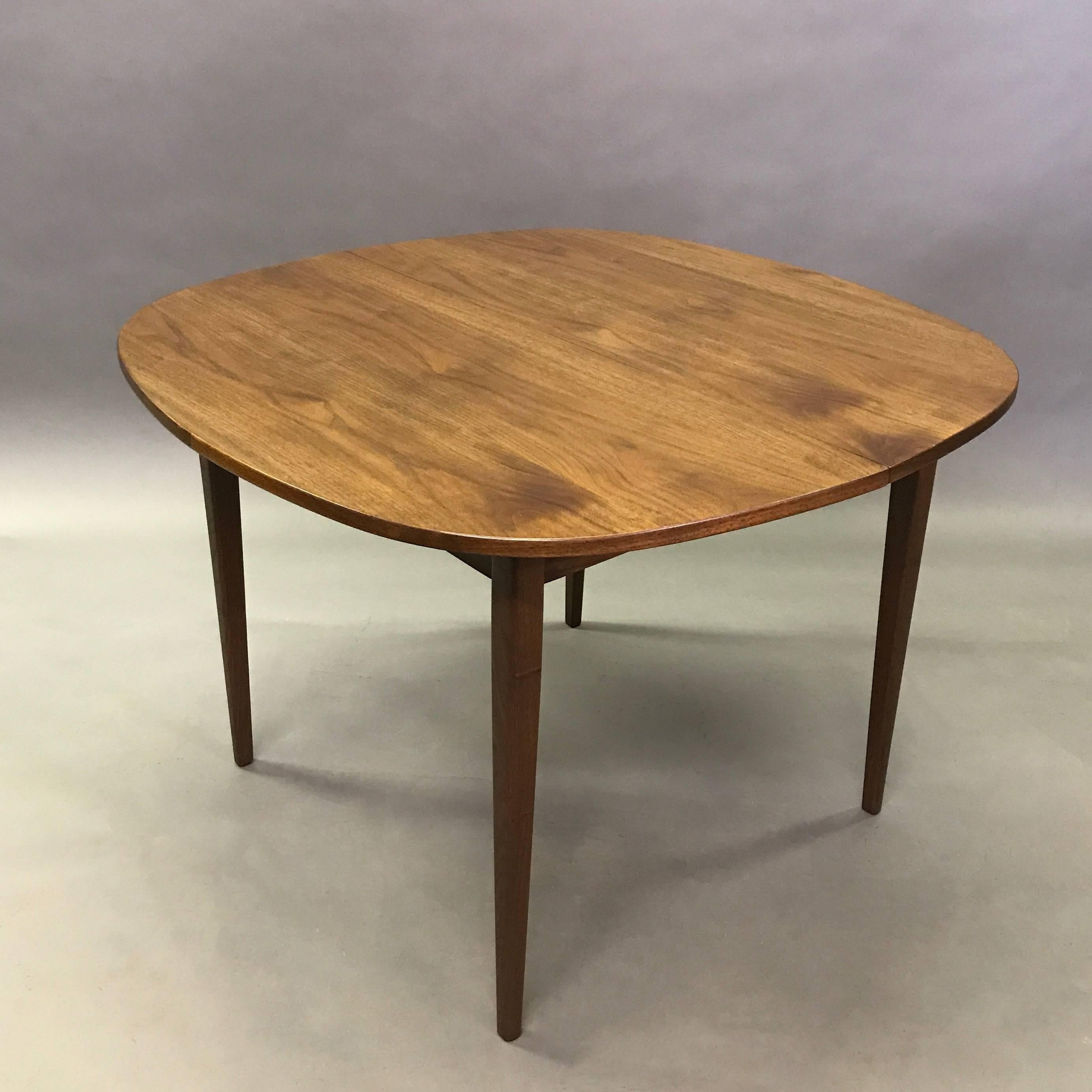 Nicely proportioned, Mid-Century Modern, solid walnut, dining table with rounded edges and tapered legs. The legs can be dismantled for transportation.