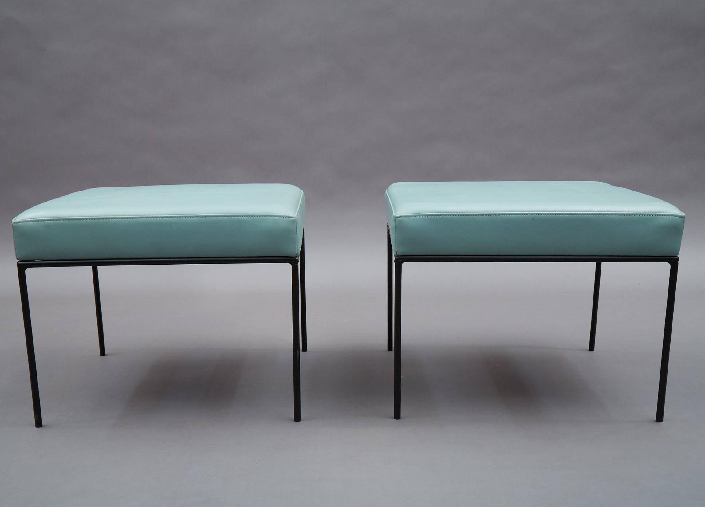 Mid-Century Modern, low-profile, square ottomans/stools/benches by Paul McCobb feature minimal, black wrought iron frames and newly upholstered powder blue vinyl seats.
