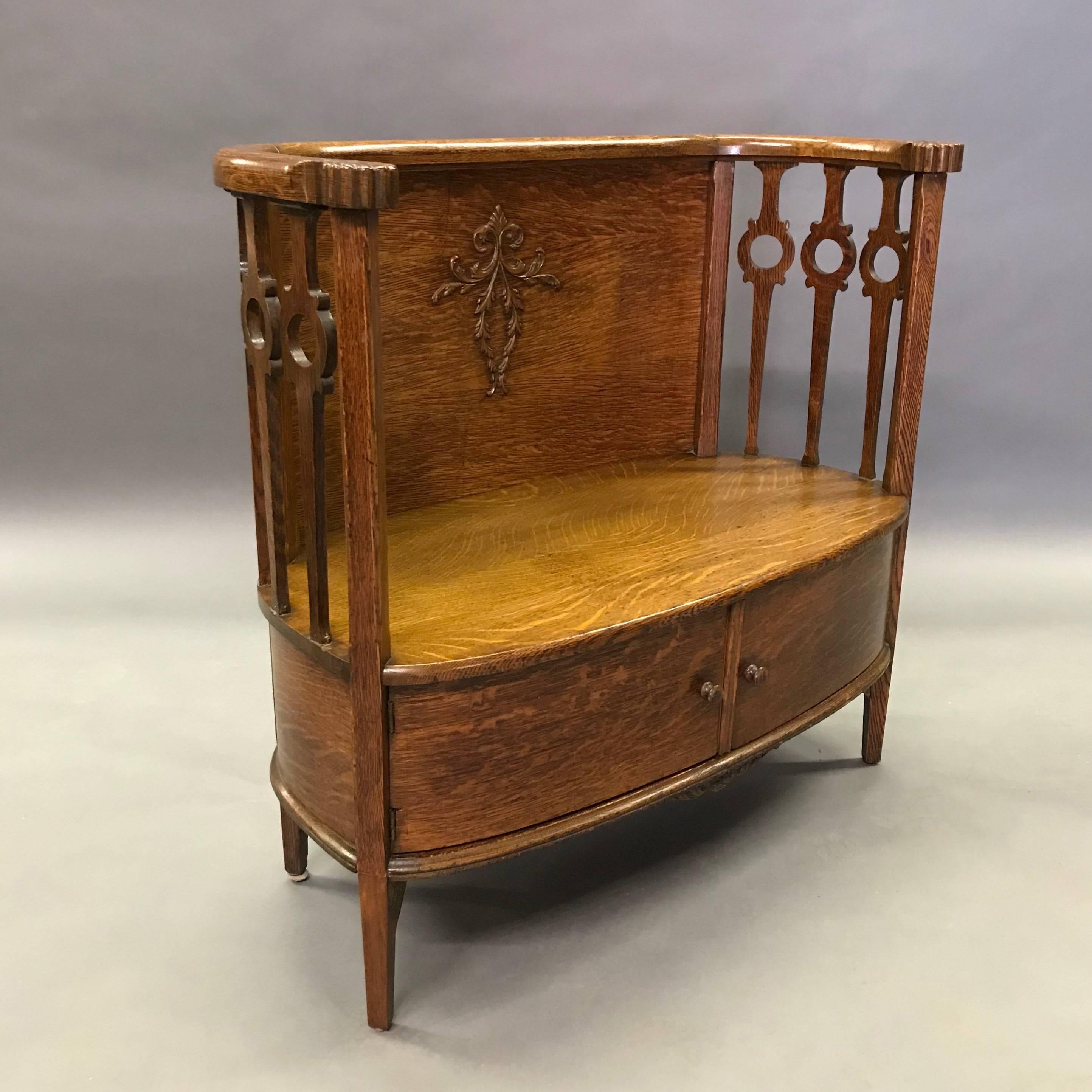 Sweet and wonderfully detailed, late 19th century, antique, tiger oak entryway settle or foyer bench features carved back and arms with hidden cabinet storage underneath.