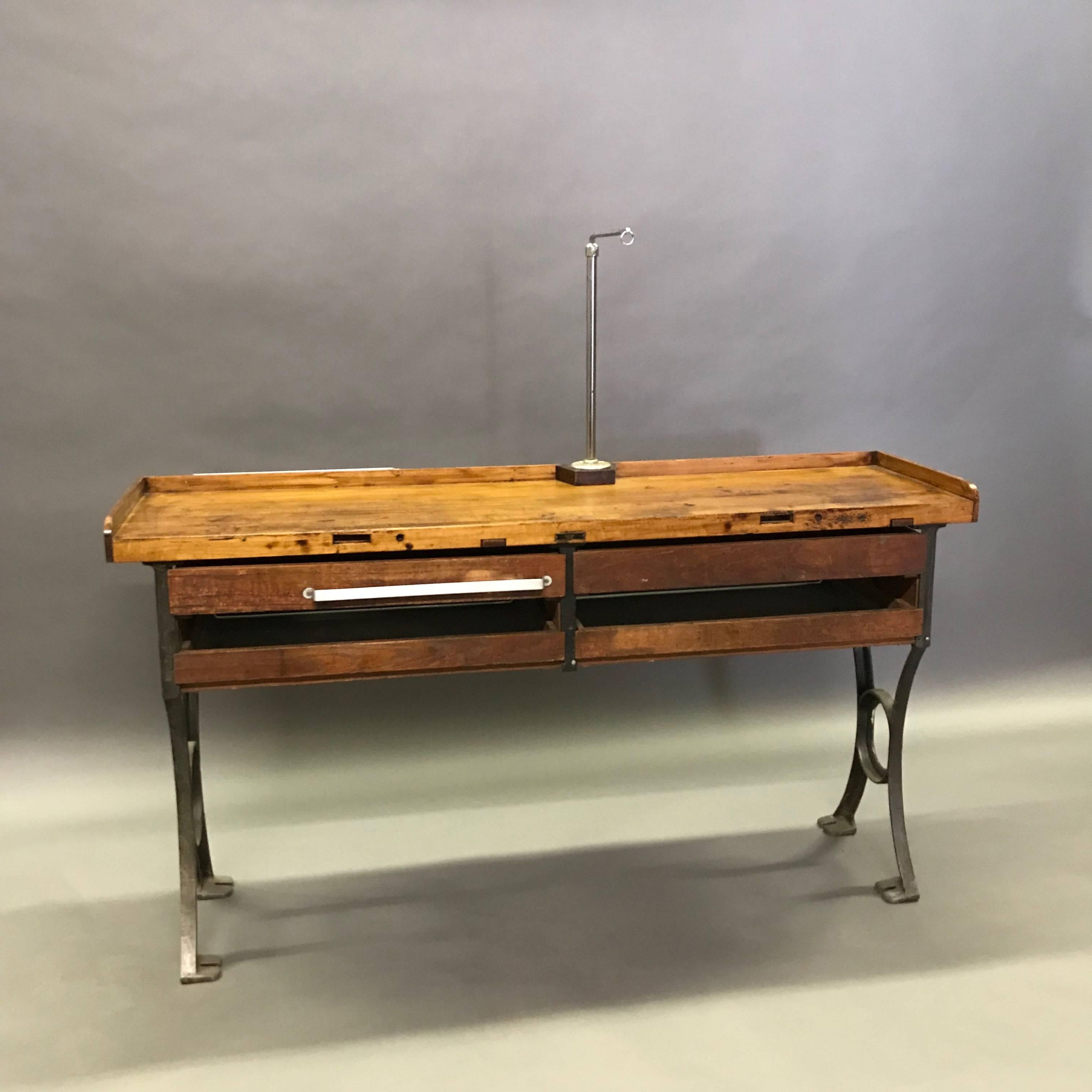 Industrial, 1930s, jeweler's work bench table features a rustic, work worn maple top with four pull-out drawers, cast iron frame and aluminum handle. The chrome machine mount on top is removable. The work surface height is 34.25 in, the seating