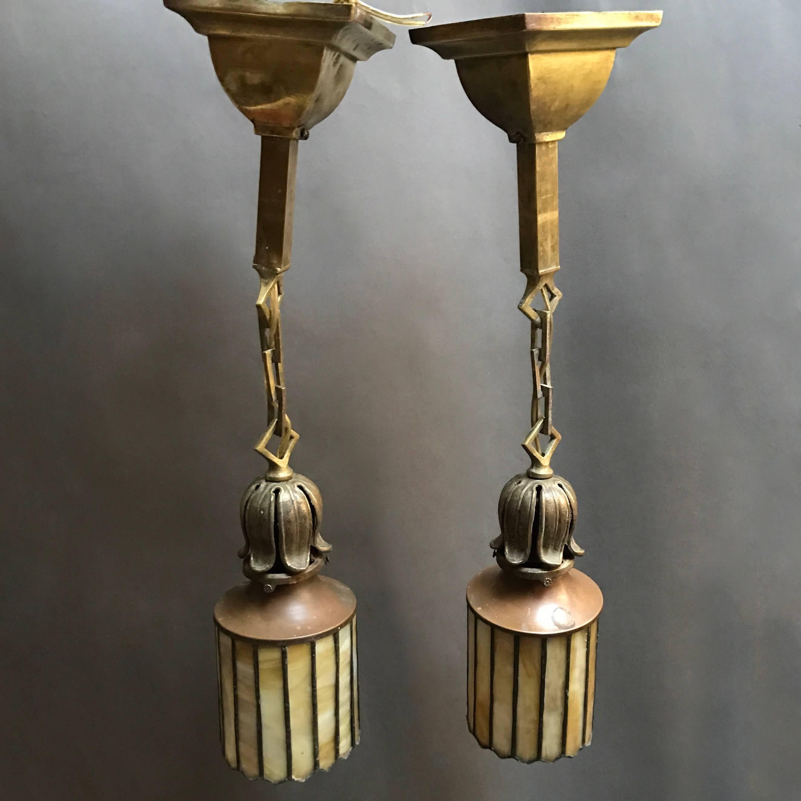 Pair of exceptional Arts & Crafts pendant lights feature stain glass shades with foliate fitters, large diamond link chains and matching canopies.