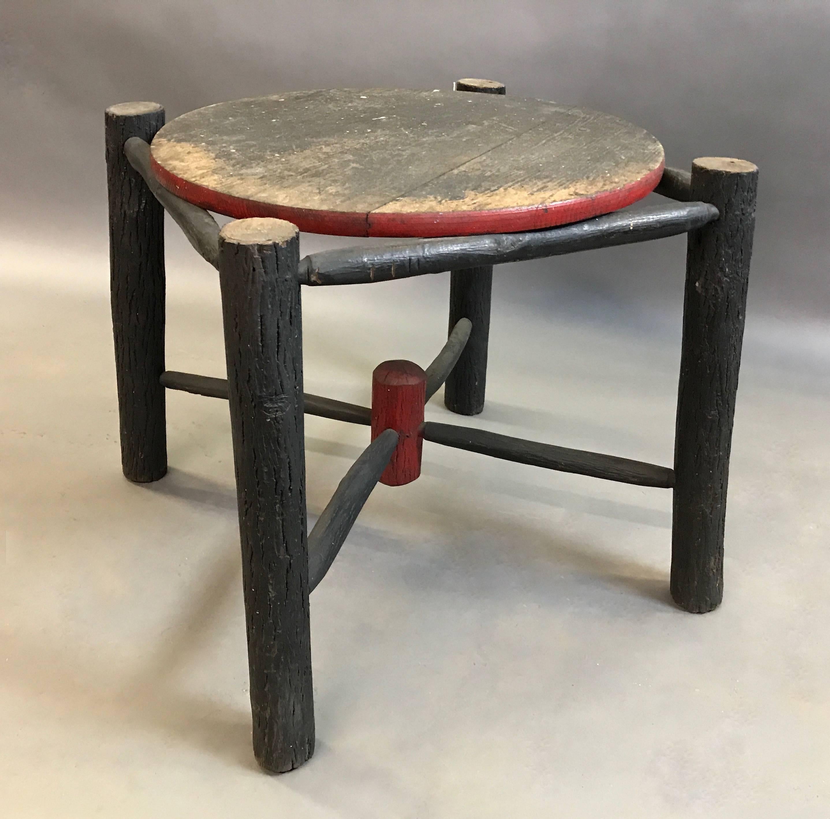 Rustic, painted log, Adirondack-style side or coffee table features four log-post legs with a centre cut circular top and additional stretchers for stability.
