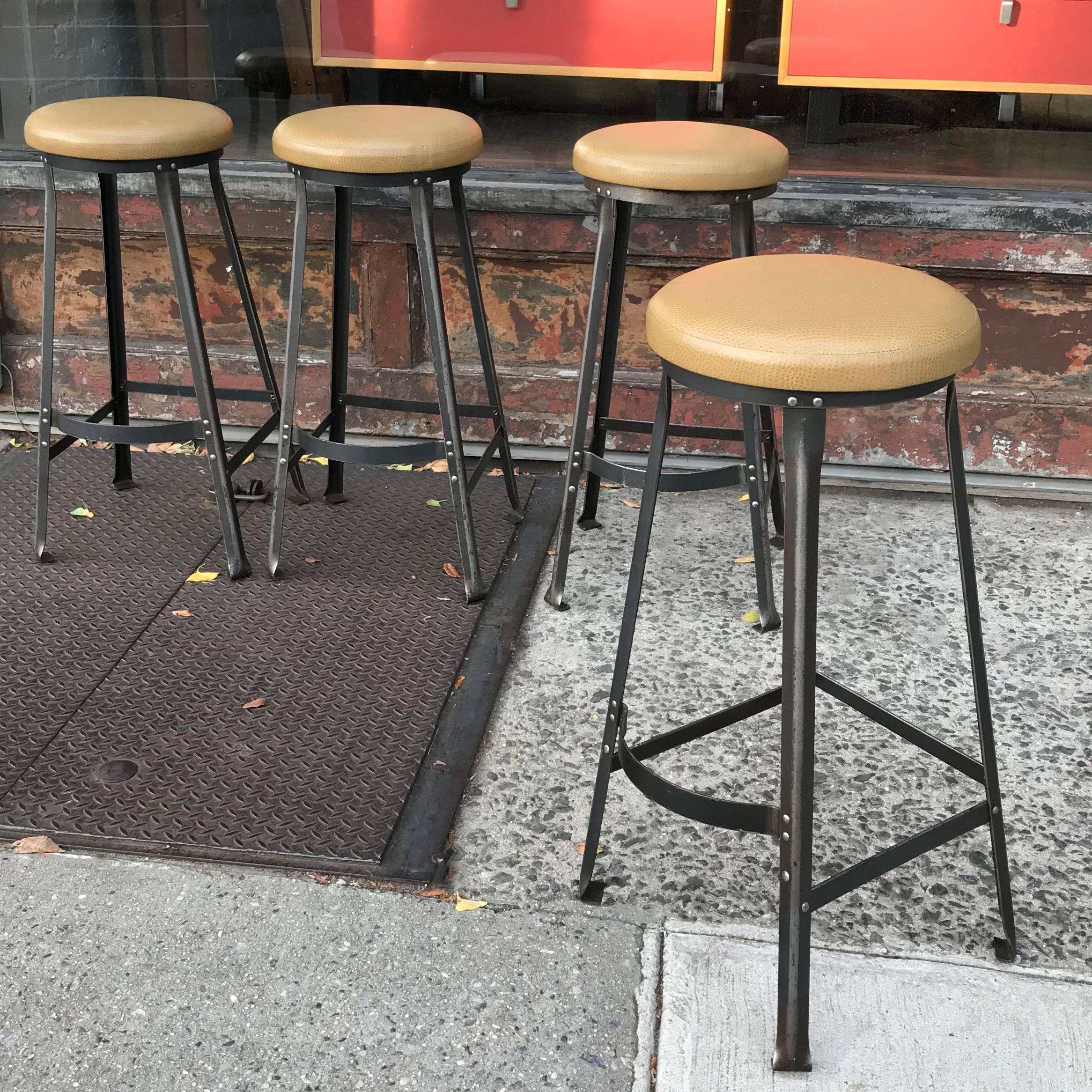 Set of four, 1940s, Industrial, barstools are newly upholstered in a faux-ostrich vinyl on stripped, angle iron bases. Seats are 14in. diameter.