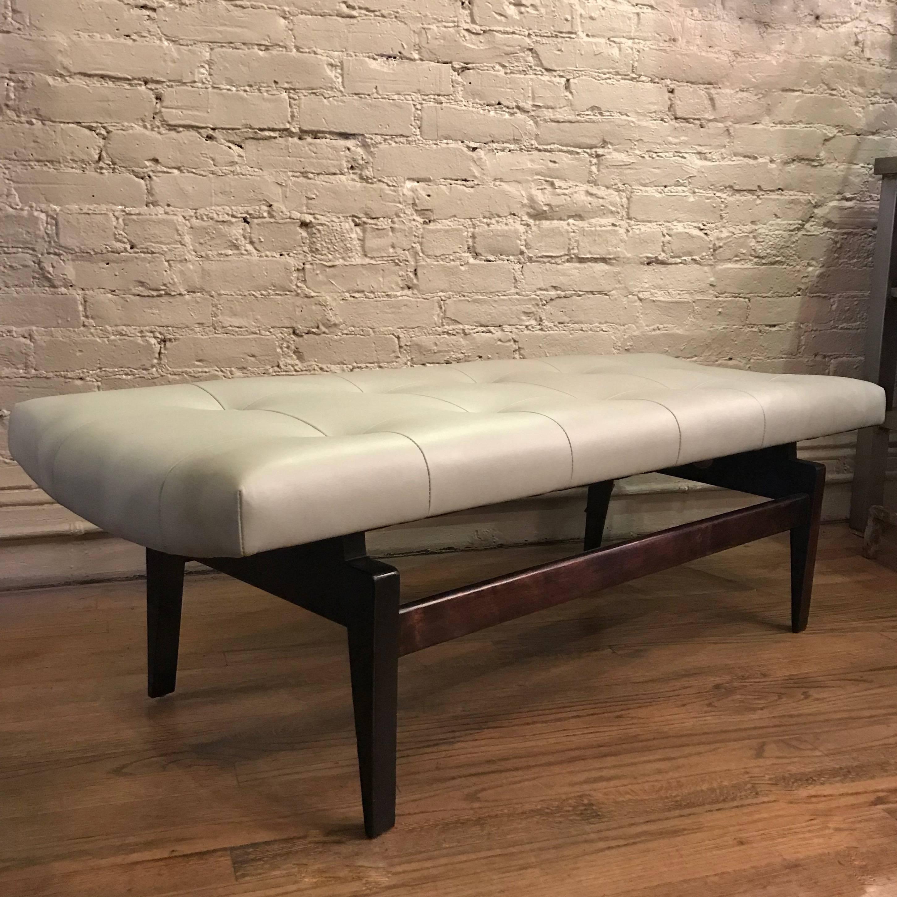 Mid-Century Modern bench by Jens Risom features a newly upholstered, tufted, powder blue leather seat with an ebonized, floating walnut frame.
