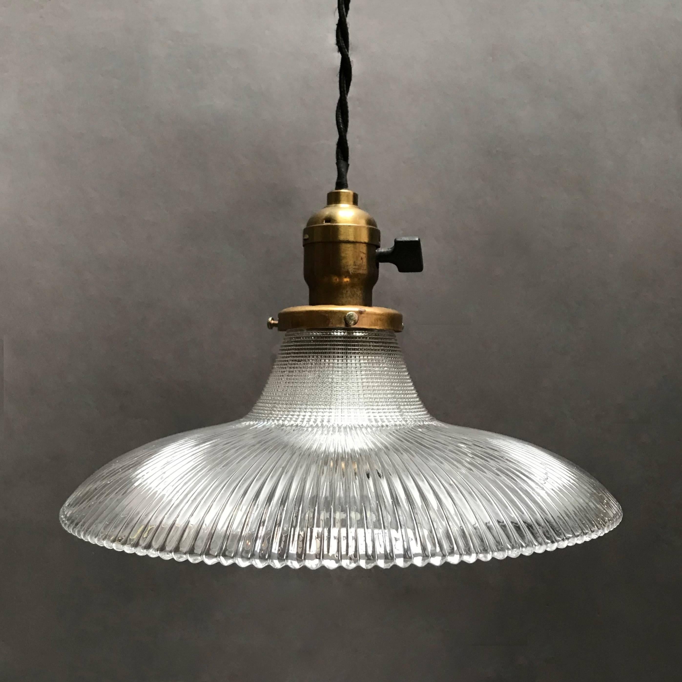Industrial, early 20th century, pendant light features a deep-cut, Dual patterned, canopy-shaped, prismatic, Holophane shade with brass turn-key fitter is newly wired for 200 watts with 48in. of braided cloth cord.