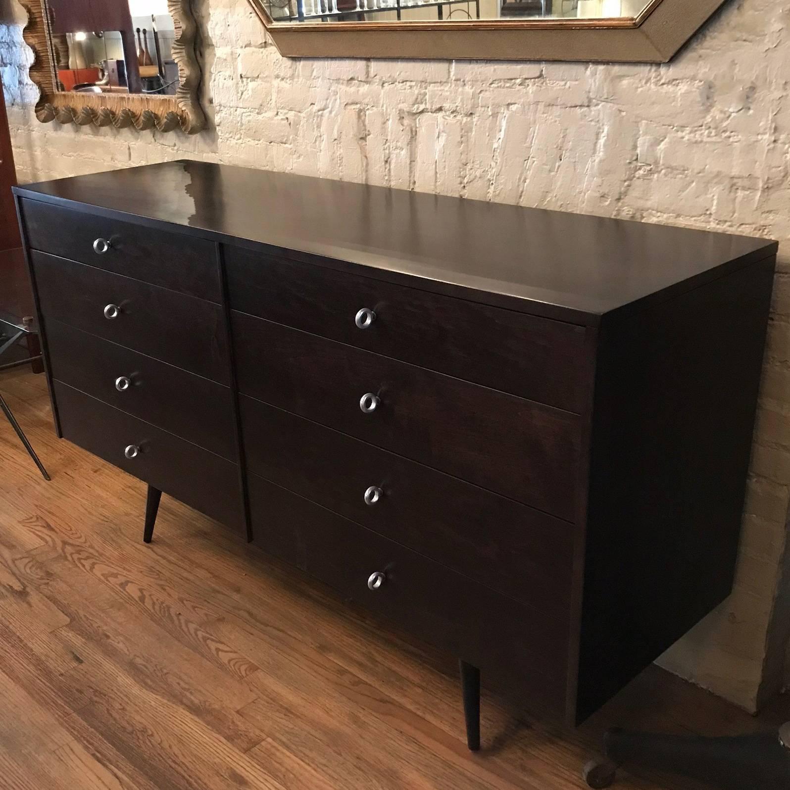 Mid-Century Modern, double wide, ebonized maple dresser designed by Paul McCobb for Planner Group, Winchendon features signature cast aluminium ring pulls and eight drawers for ample storage.