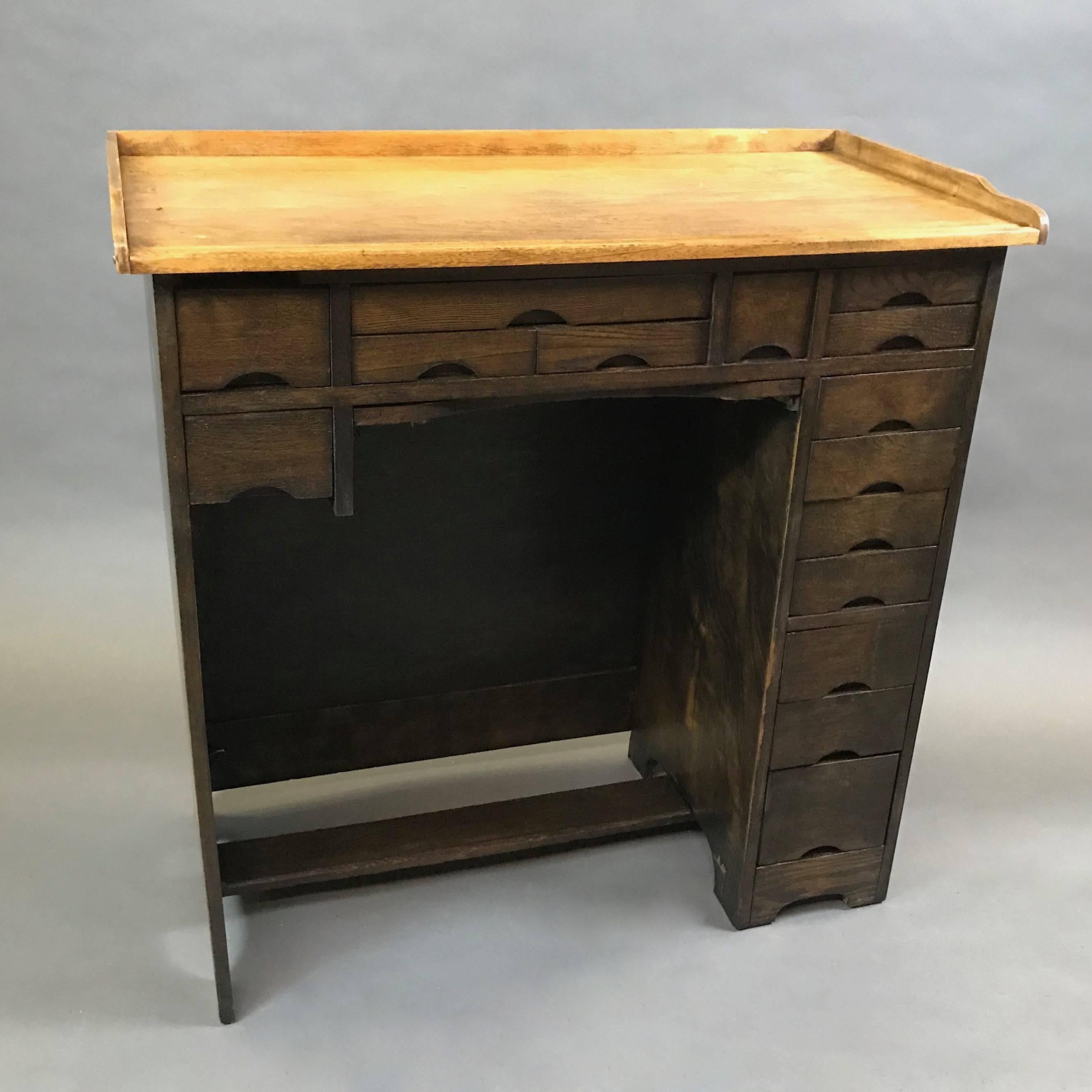 Industrial, maple, watchmaker’s desk with 15 drawers of various size is newly restored in a contrasting, two-tone finish. There is a framed canvas ledge that pulls out below the center drawers to catch small parts. This piece functions great as a