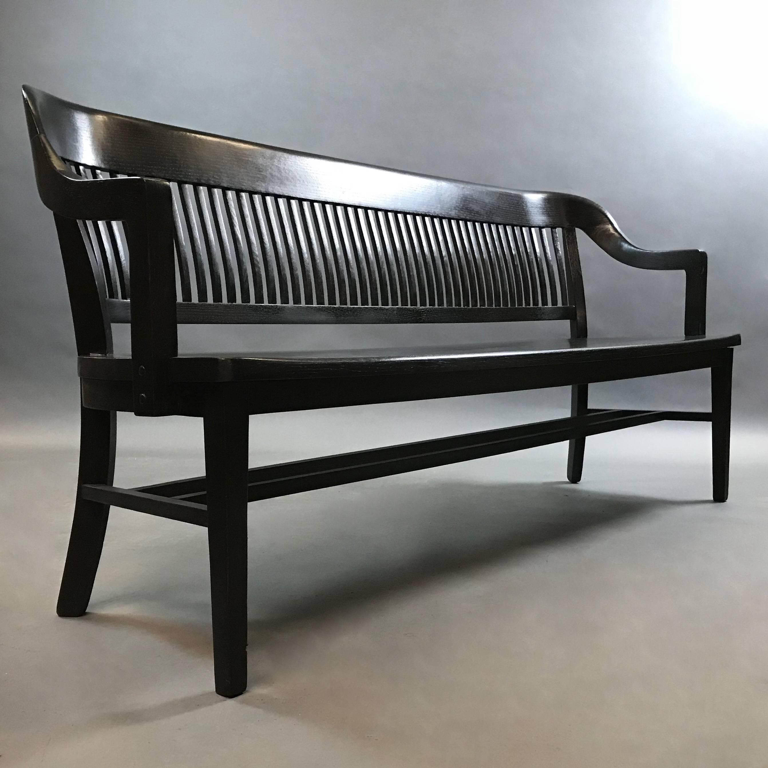 Classic, 1940s, US courthouse, oak, armchair bench with slat backrest is stunning in a newly ebonized finish. Arm height is 27in