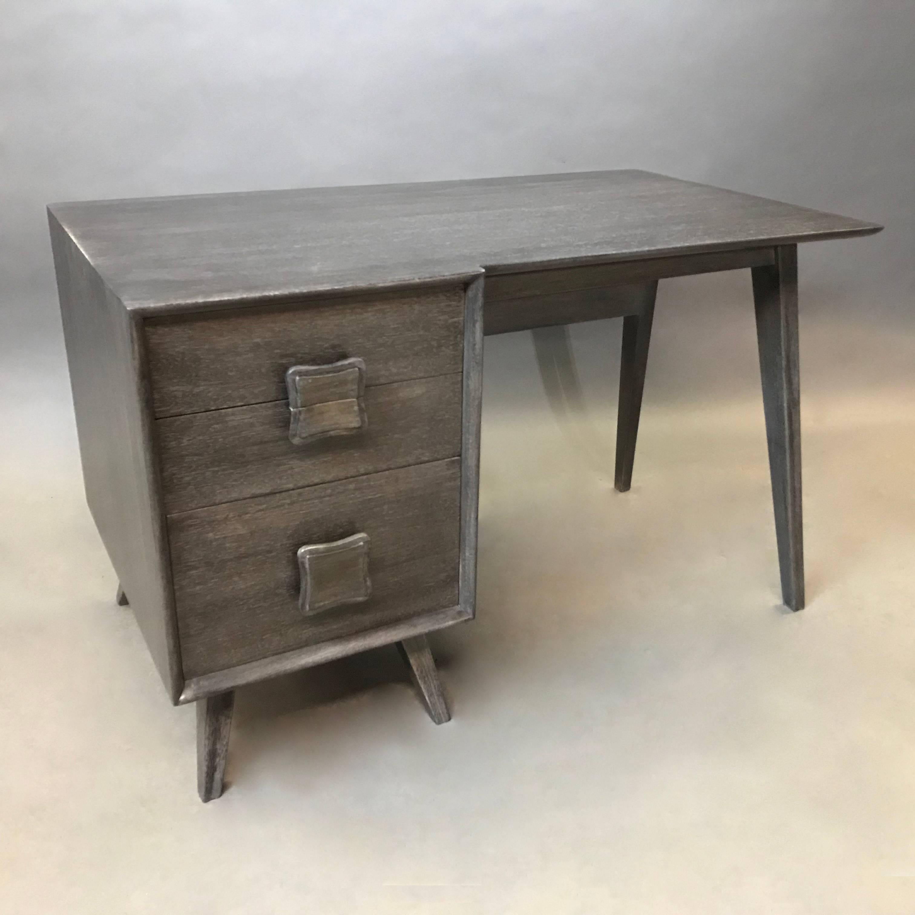 Mid-Century Modern, ebonized ash, single pedestal desk features decorative pulls on it's three drawers, tapered legs and a display shelf in the front so the desk is presentable on all sides.