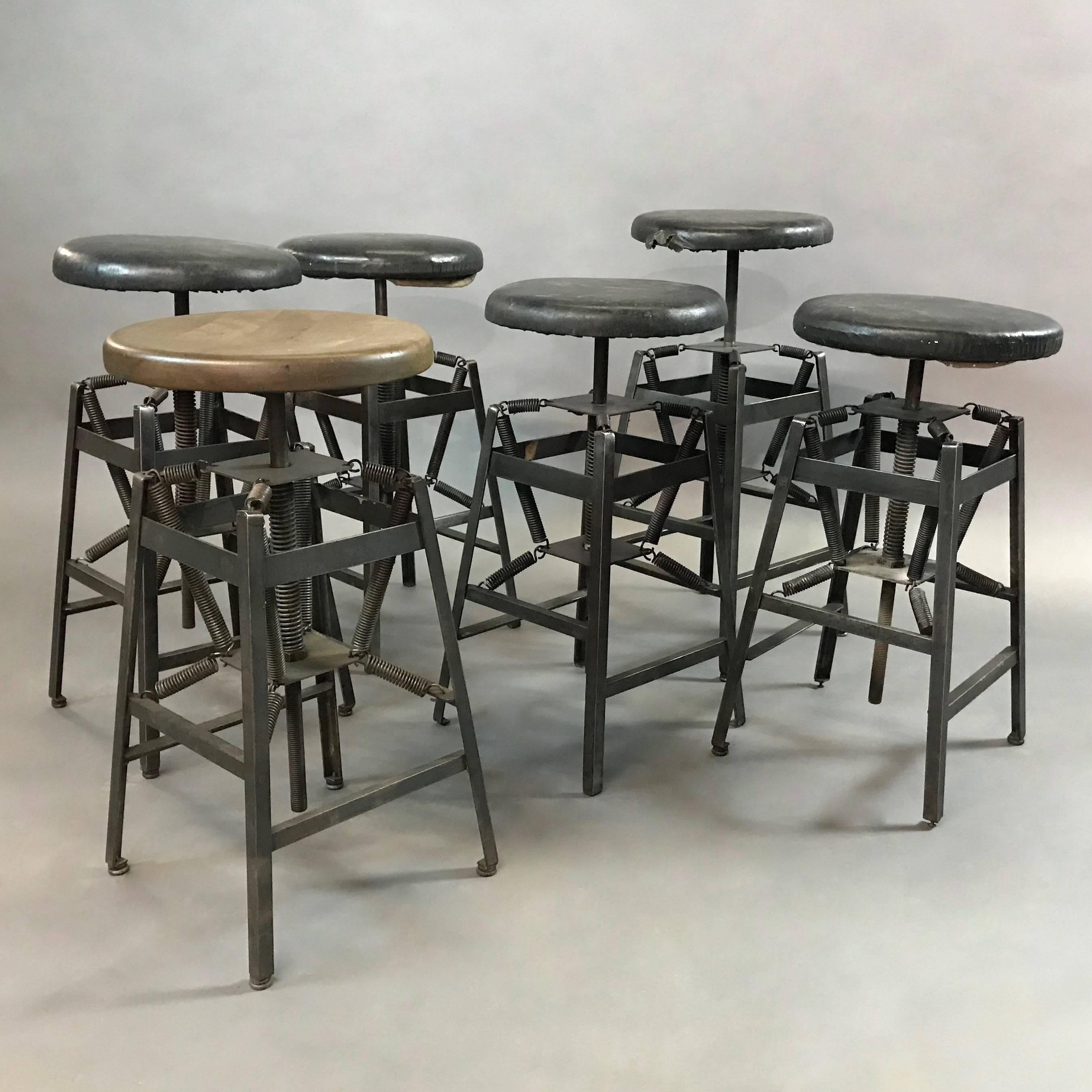 Industrial drafting stool designed by Charles E. Miller for American Cabinet Co. features an adjustable height, steel, spring suspension base with original black vinyl seats. The seats can be re-upholstered or changed to wood. Seat diameter and foot