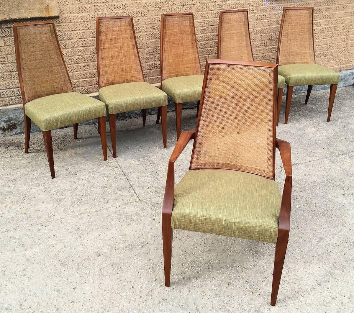 Set of six, tall, dining chairs by Grosfeld House feature sculpted walnut frames with caned backs and linen blend upholstered seats. The set consists of five side chairs and one captain. Captain chair is: 22 W x 19.5 D x 40.5 H, seat height: 19