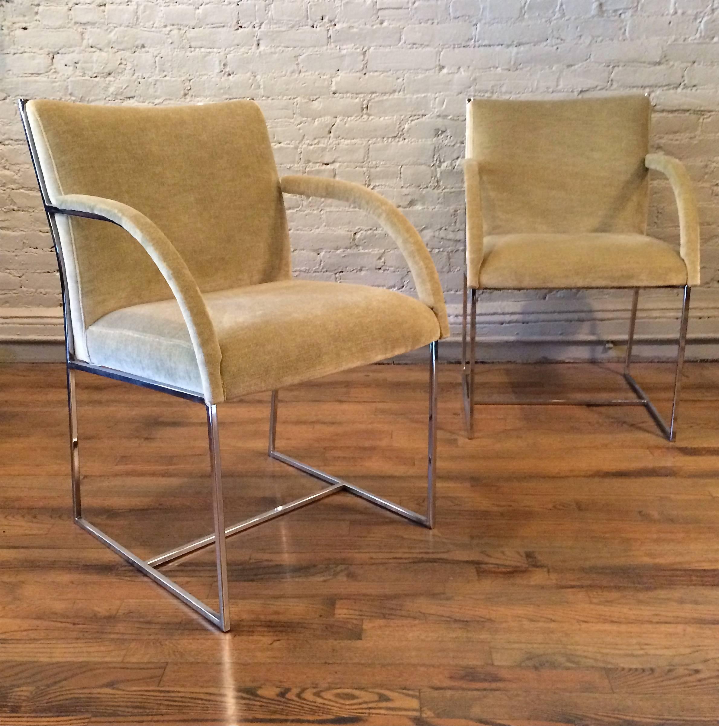 Pair of Mid-Century Modern armchairs in the style of Milo Baughman feature chrome frames with arching arms, newly upholstered in light pistachio green velvet.