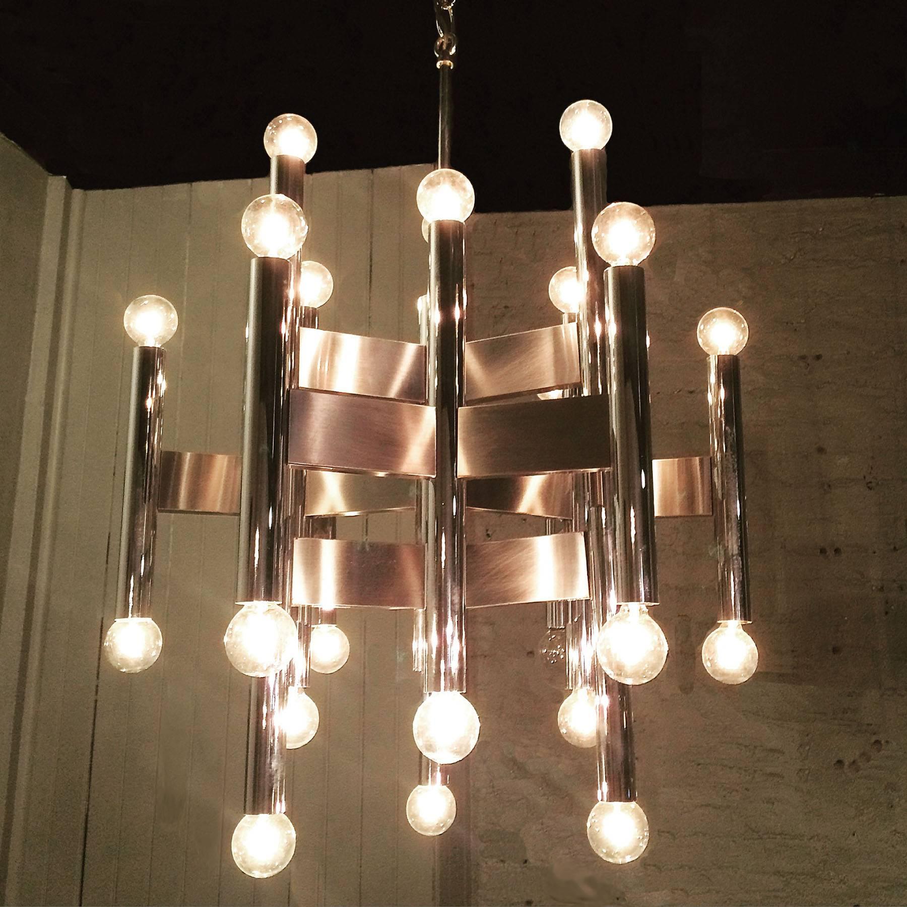 Italian modernist chrome chandelier attributed to Gaetano Sciolari has alternating tubular stems connected by flat panels.

The fixture is 18.5in diameter x 25.5in height, overall height with chain is 32in.