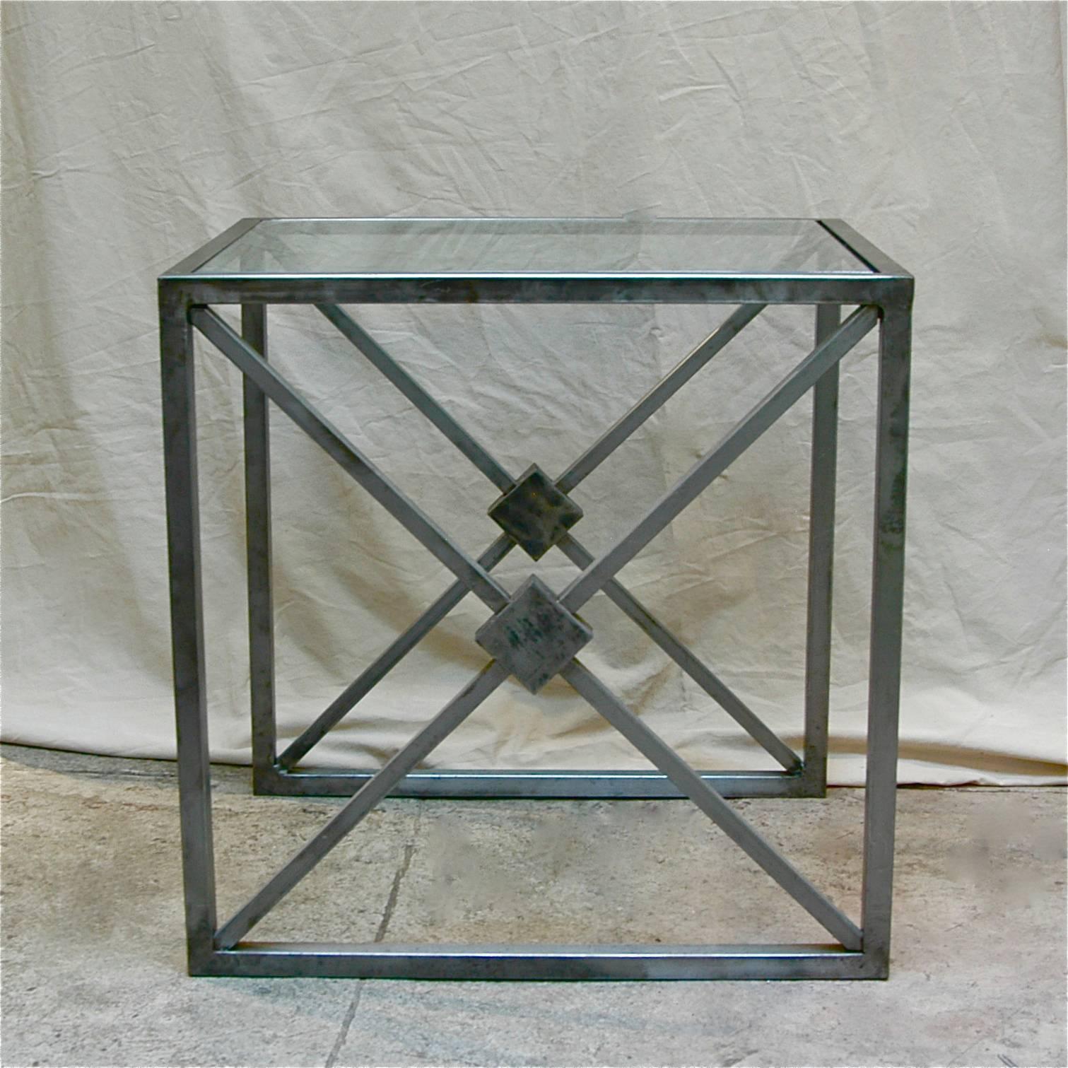 Hollywood Regency side table with brushed steel frame and glass top.