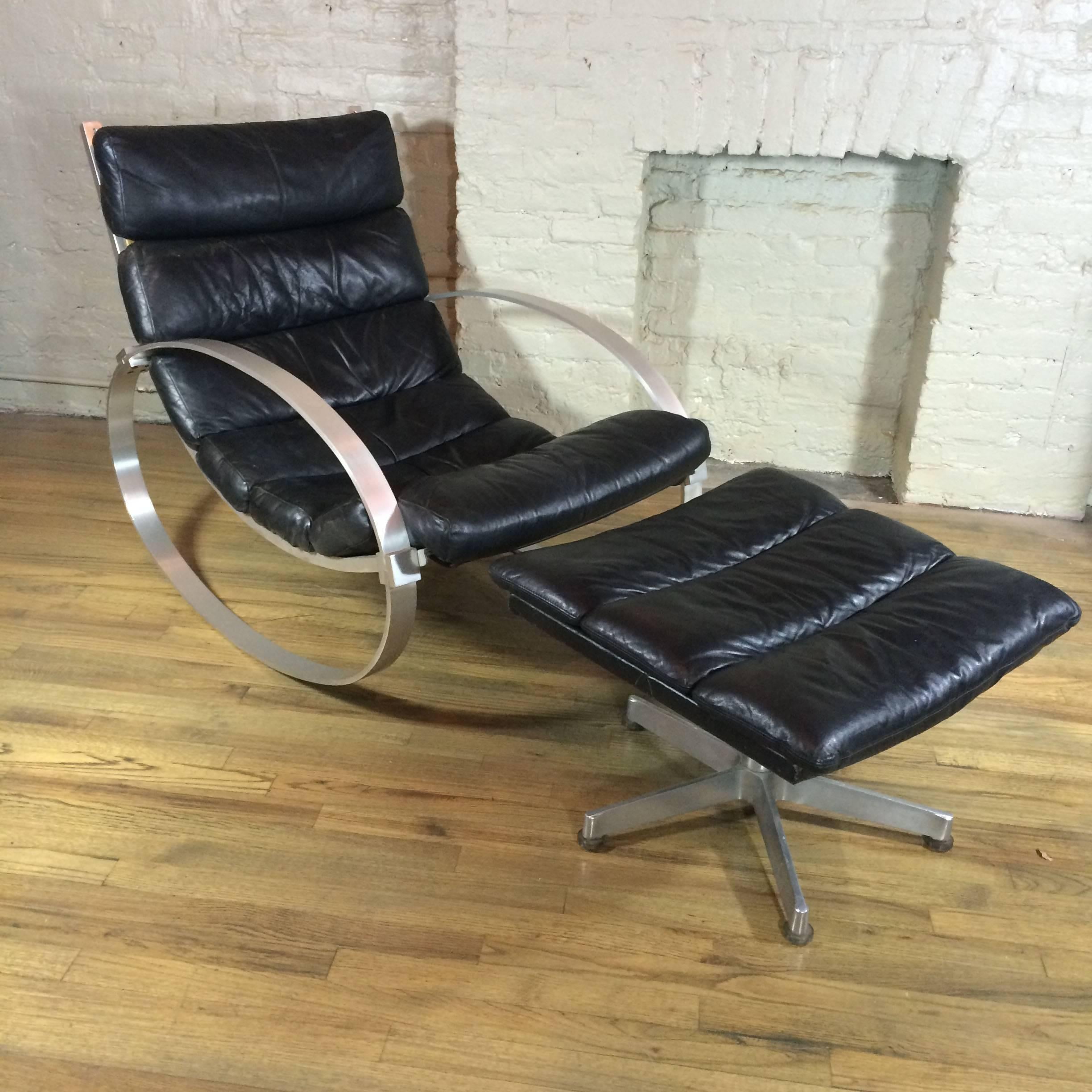 Modernist rocking lounge chair with matching ottoman designed by Hans Kaufeld, Germany features it’s original black leather rolled upholstery with brushed steel frame.

Measures: Chair is: 40