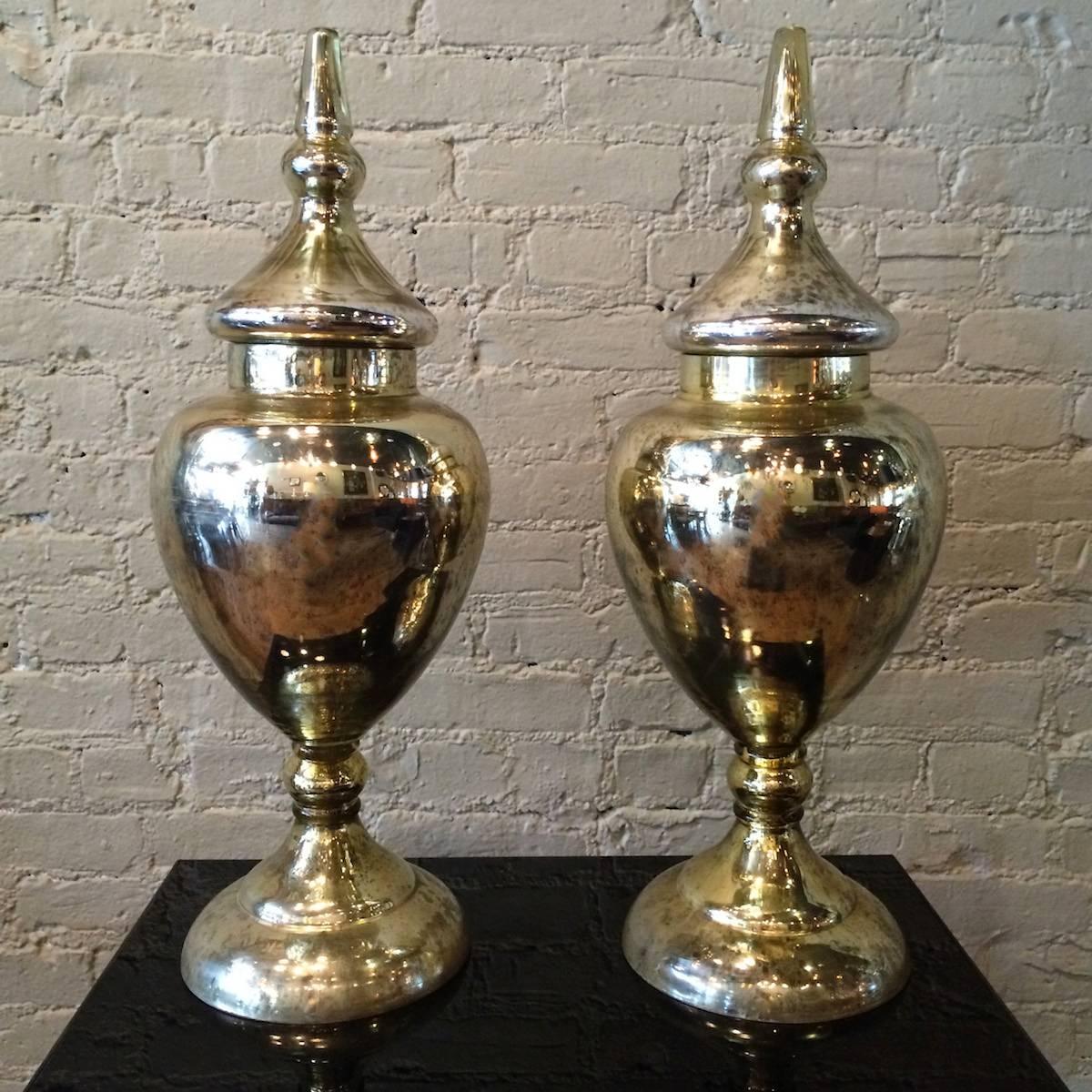 Pair of monumental, tall, mercury glass urns with decorative etching on the lids and faceted finials and overall lovely patina.