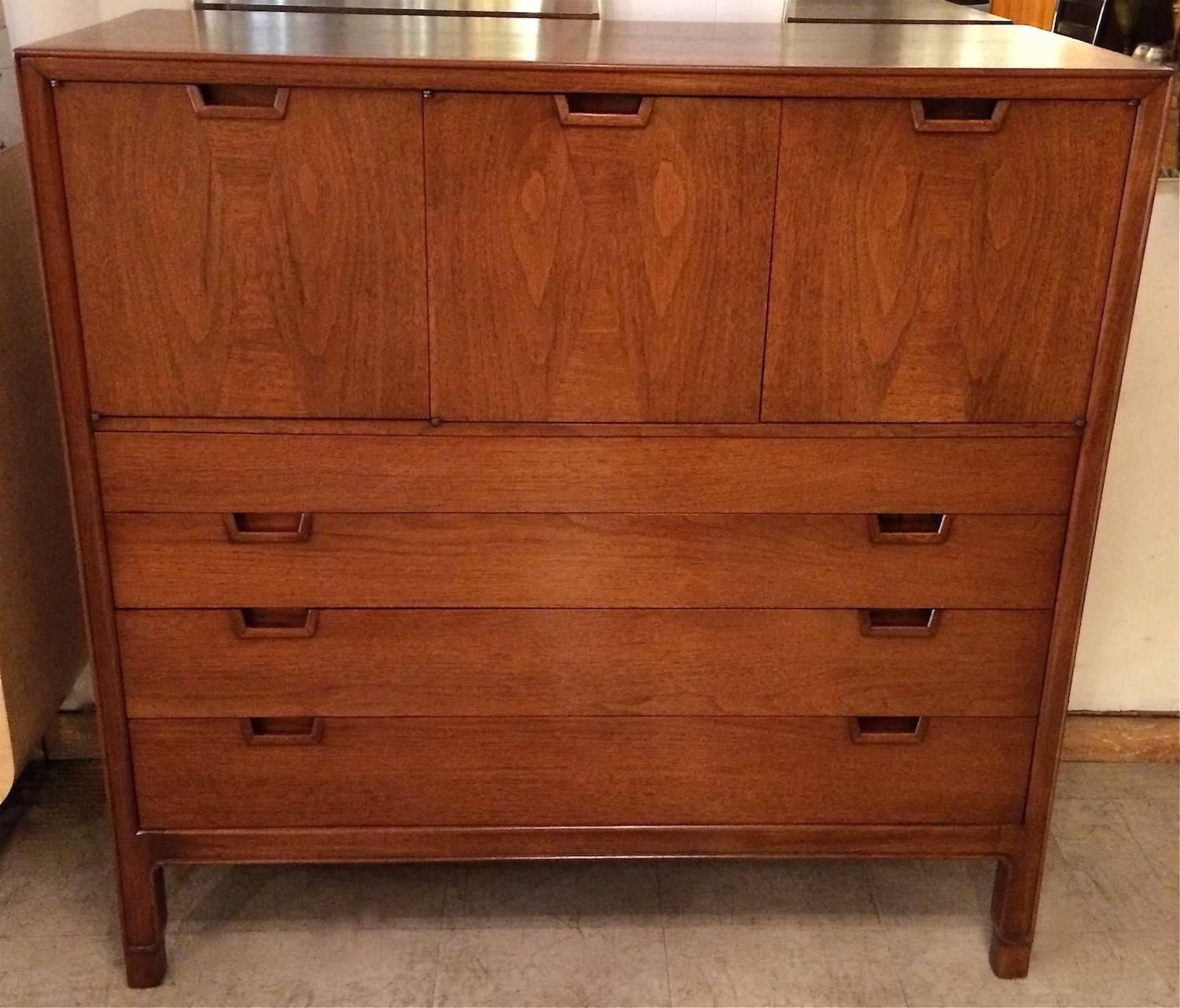 Mid-Century Modern, walnut, highboy dresser or gentleman's chest by John Stuart for Janus Collection with compartments on top and four drawers on the bottom. Fine details throughout featuring recessed pulls and inlaid details on the top doors.