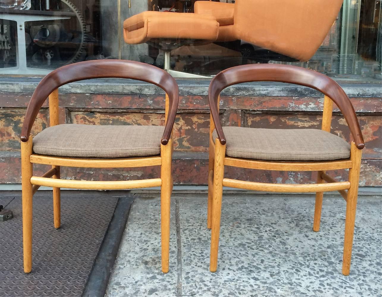Pair of vintage, barrel back, armchairs by Brockmann Petersen for Poul Jeppesen with two-toned, walnut continuous backs and ash frames, and upholstered woven cotton blend seat cushions. Chairs are marked Model 123 Denmark.