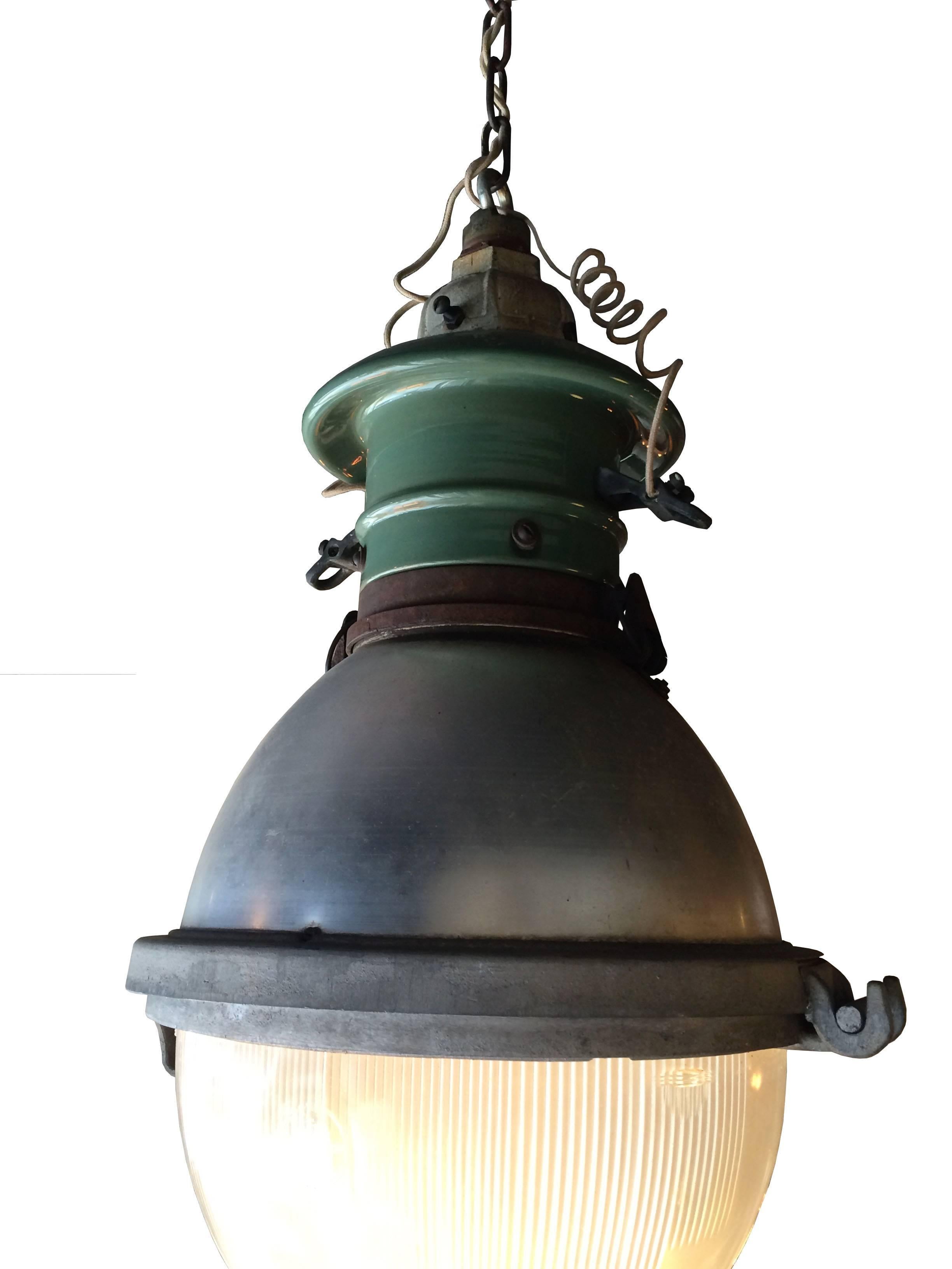 Impressive and rare, Industrial, street light pendant with cast iron and green porcelain fitter, spun aluminum dome casing and Holophane glass shade. Glass shade has Holophane logo in raised lettering with 
