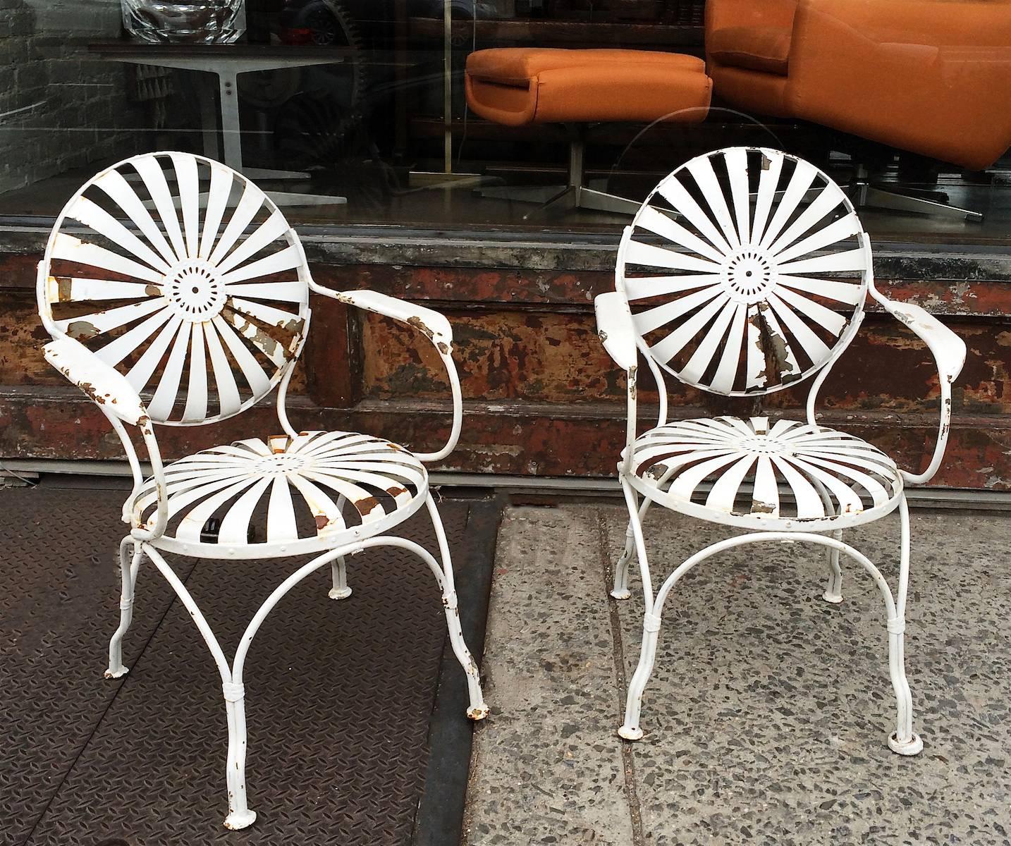 Pair of painted steel, French, garden armchairs by Francois Carré with sunburst seats and backs in original, rustic 