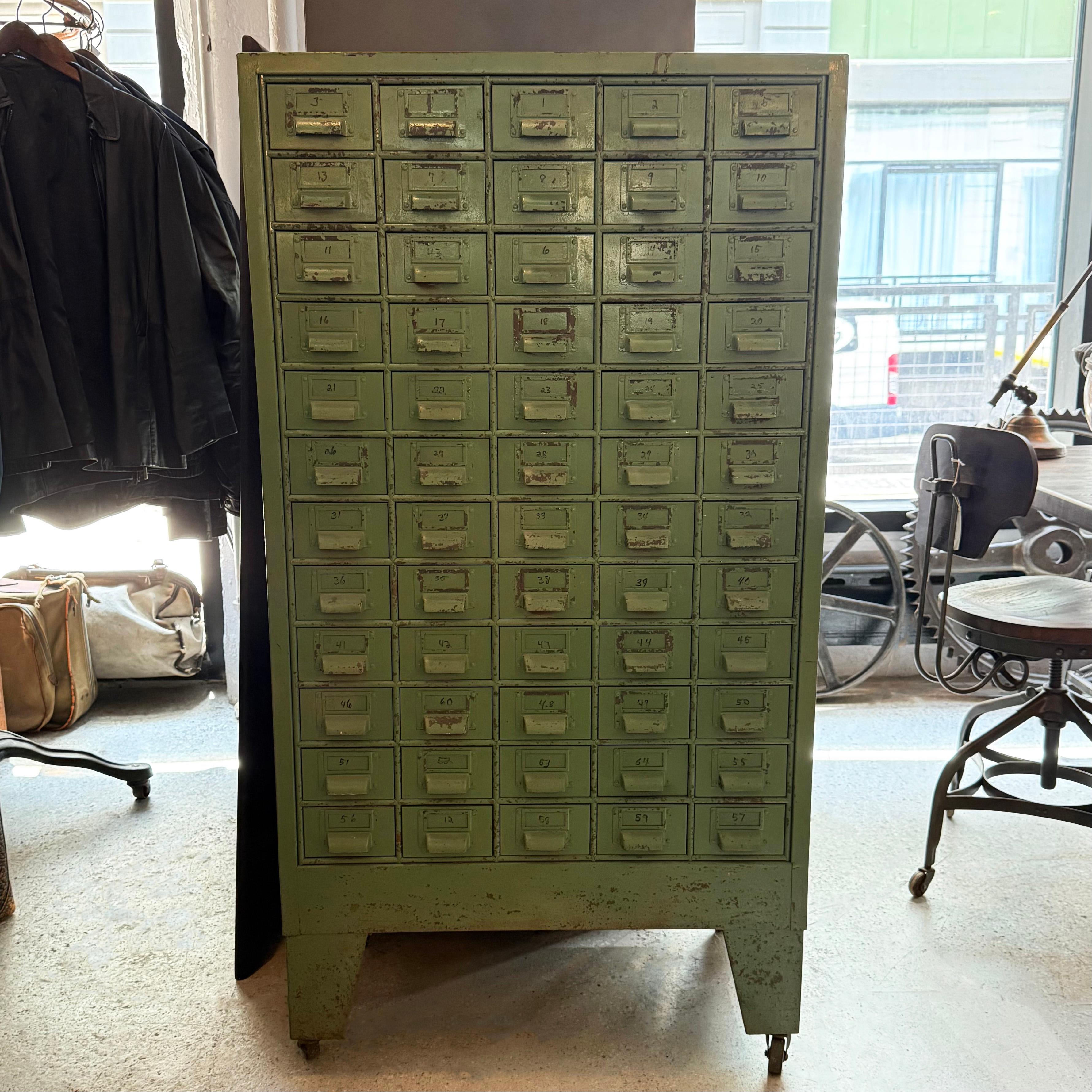 This handsome, mid 20th century, industrial steel, multi-drawer tool cabinet features 60 individual drawers at 5 w x 3 ht x 14.5 d inches for storage of small parts. Each drawer is fitted on the front with a label holder with cup pull but the