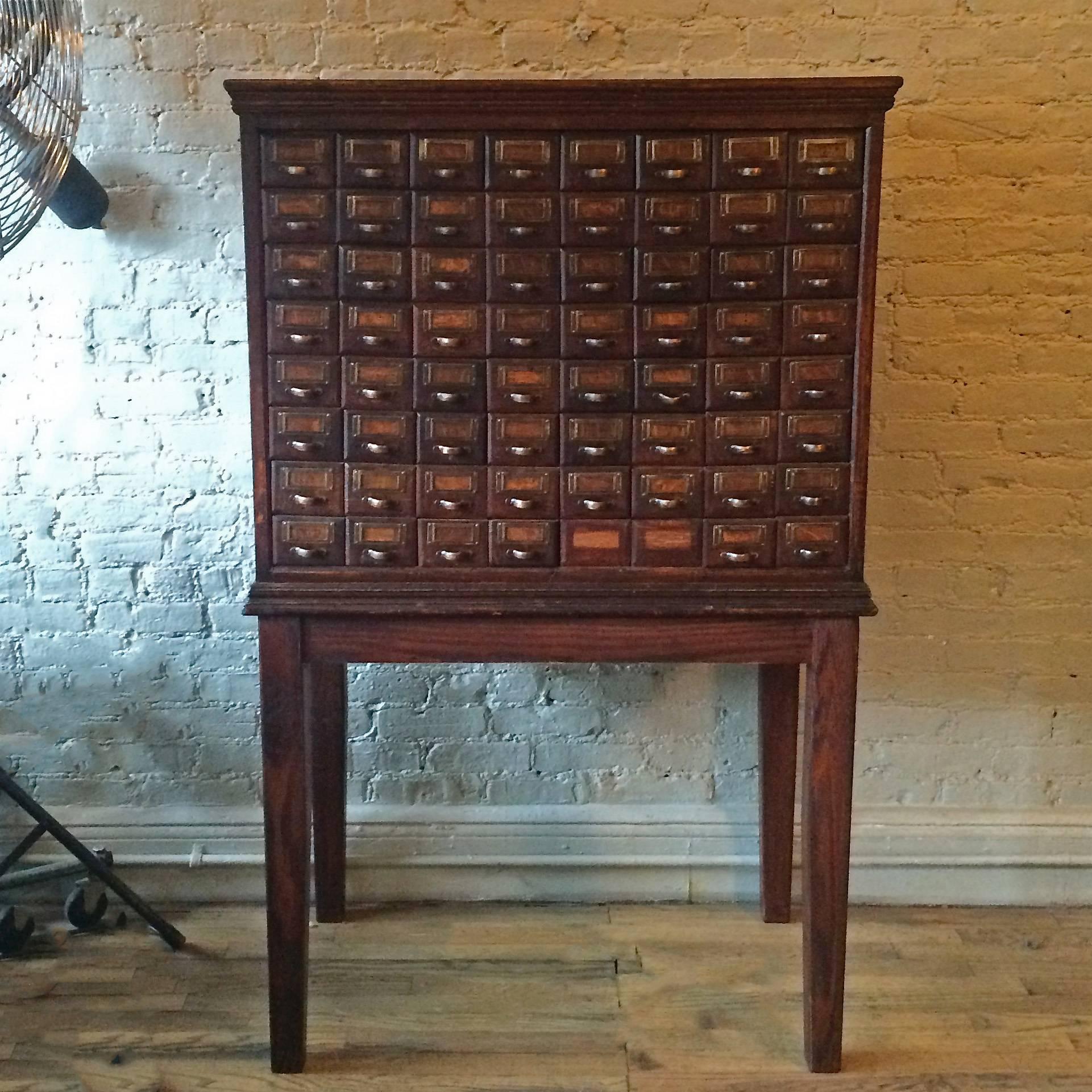 Handsome, antique, late 19th century, American, oak, apothecary medicine cabinet with 64 small drawers with brass pulls and wainscot side panels is newly restored. We have the original hardware for the bottom 2 drawers that can be replaced.

Cabinet