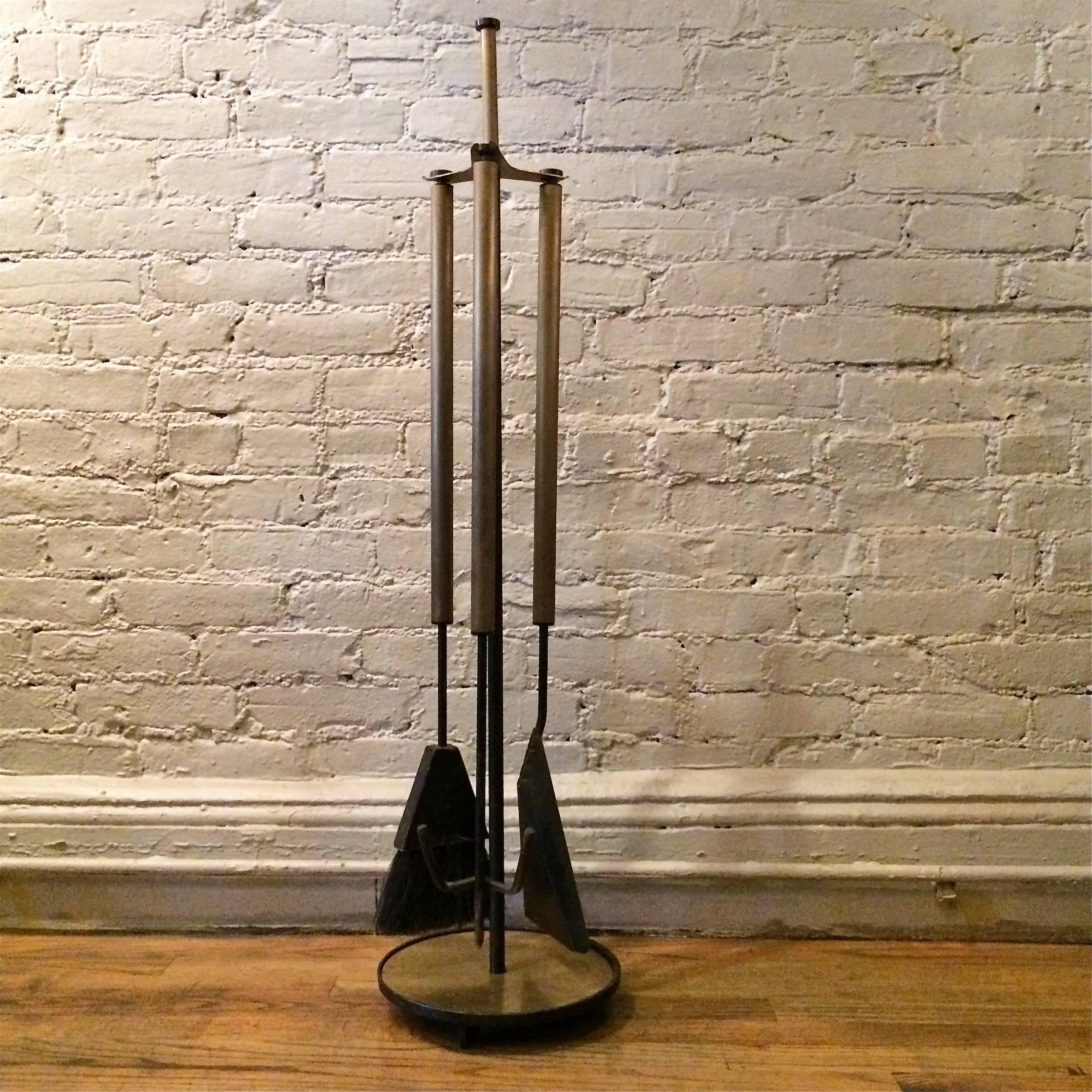 Four-piece set of Mid-Century Modern, fireplace tools are wrought iron and brass.