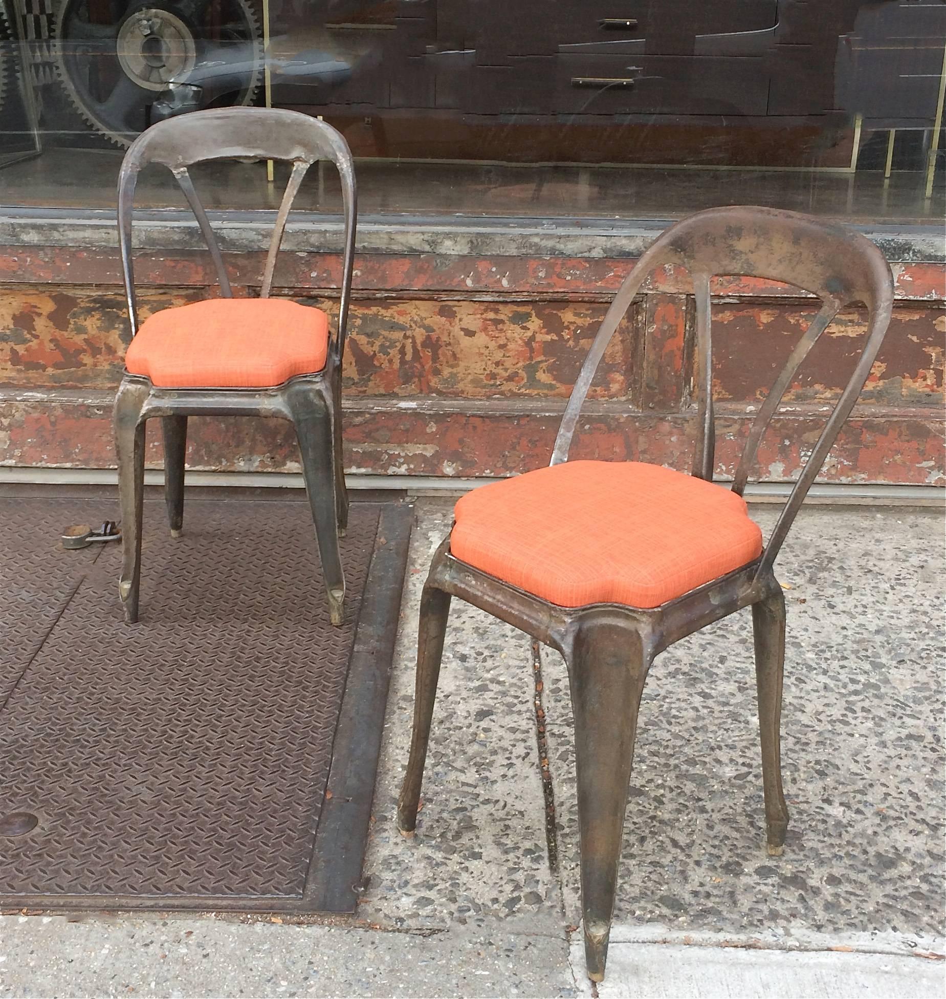 Pair of unique, brushed steel, Tolix café chairs designed by Xavier Pauchard, circa 1920s with newly upholstered seats in outdoor fabric.