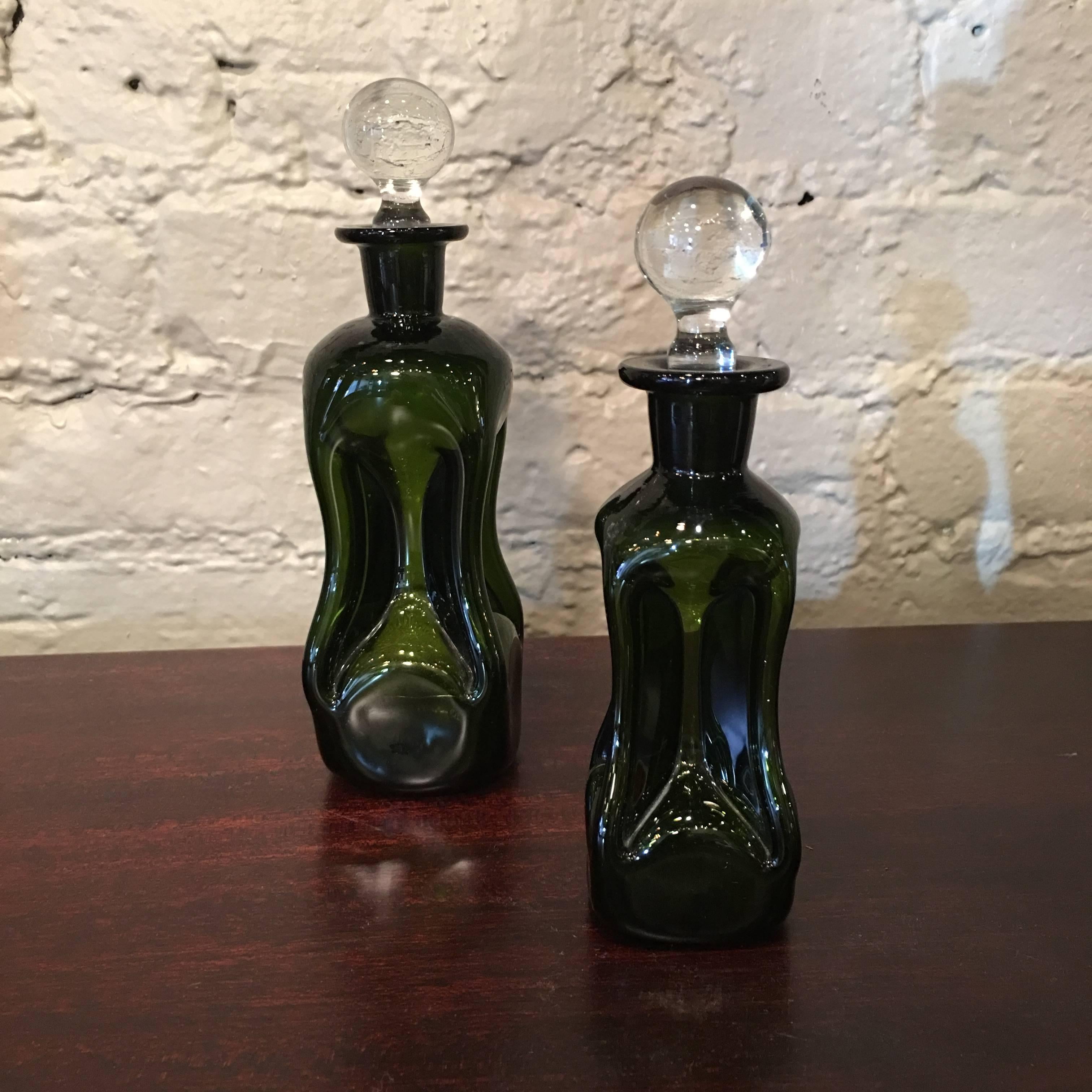 Pair of Mid-Century, dimpled, green glass perfume bottles with clear glass stoppers.

Measures: Large bottle: 2