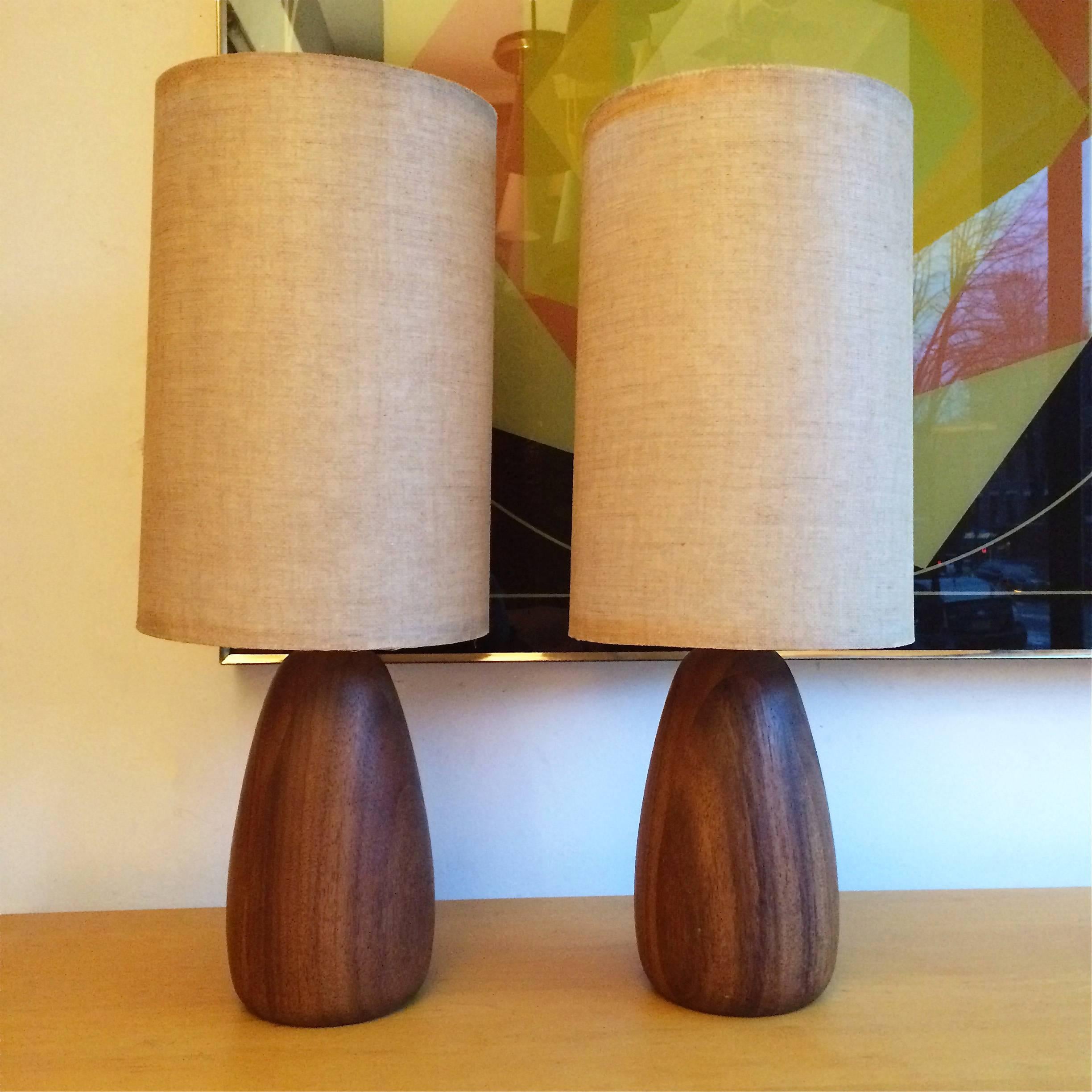 Pair of petite, Mid-Century Modern, table tables with acorn shape, walnut bases, brass necks and original grasscloth shades.

Measures: 5" diameter x 22" overall height, walnut base is 9" height.
