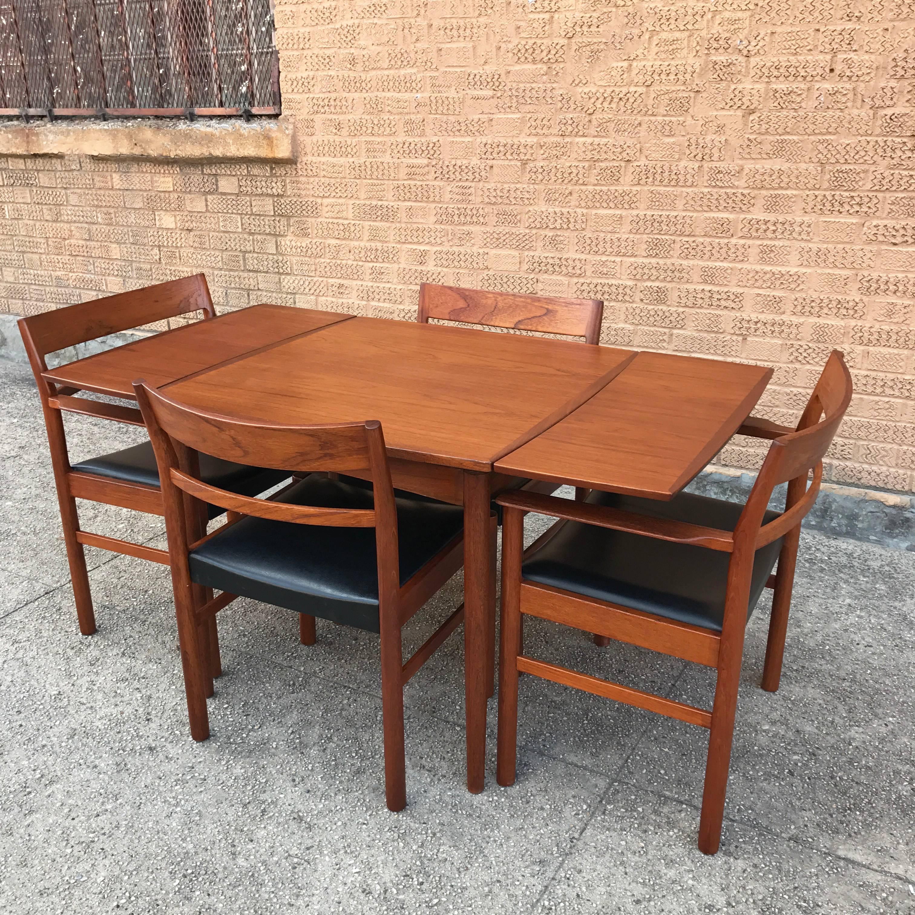 Set of four, newly restored, Danish modern, teak dining chairs by Kurt Ostervig are comprised of two captain armchairs and two side chairs. The black vinyl seats are original.

Side chairs measure: 20 W X 17 D X 31 HT, seat height: 17.