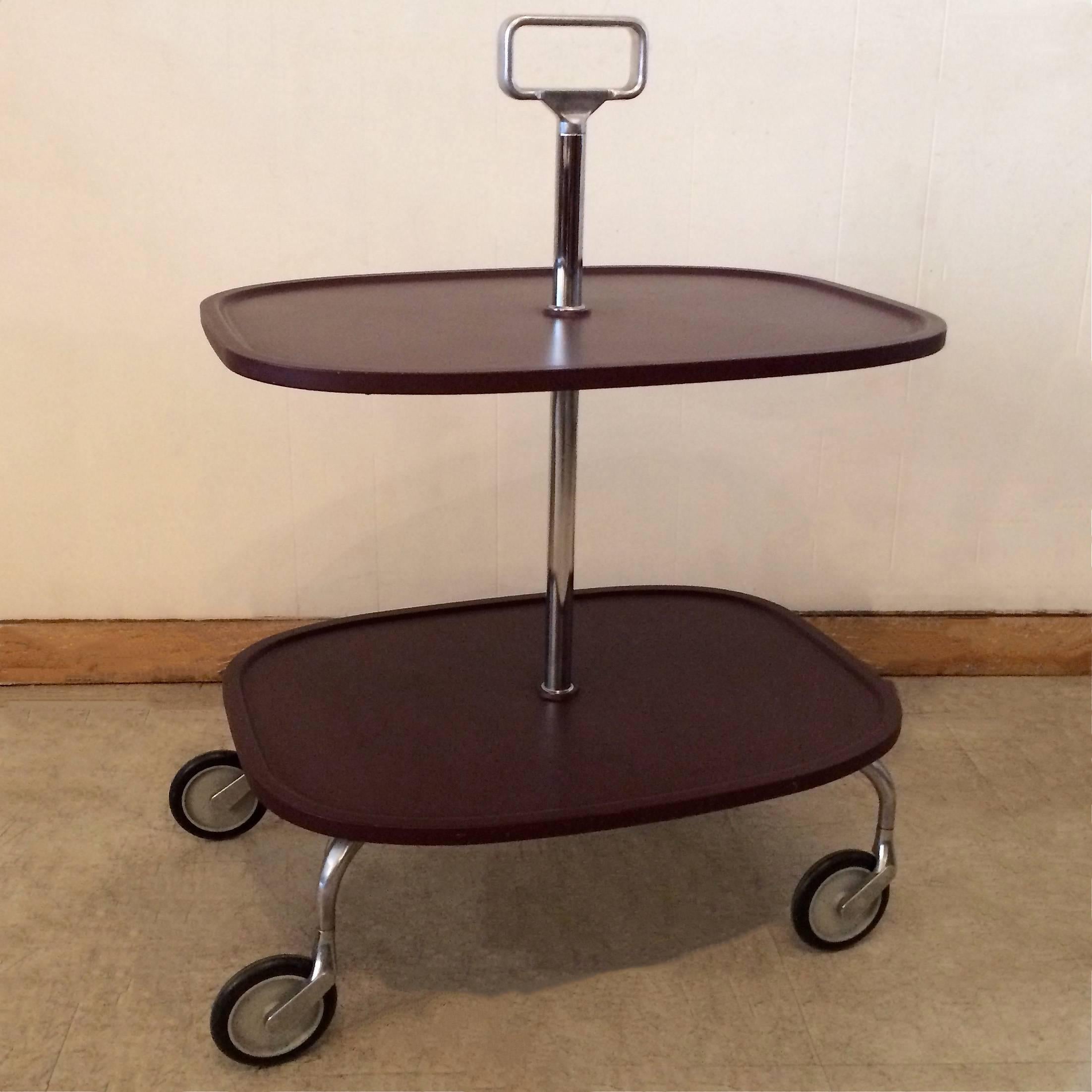 Chrome, rolling, server or bar cart by Kartell features two molded resin tiers.