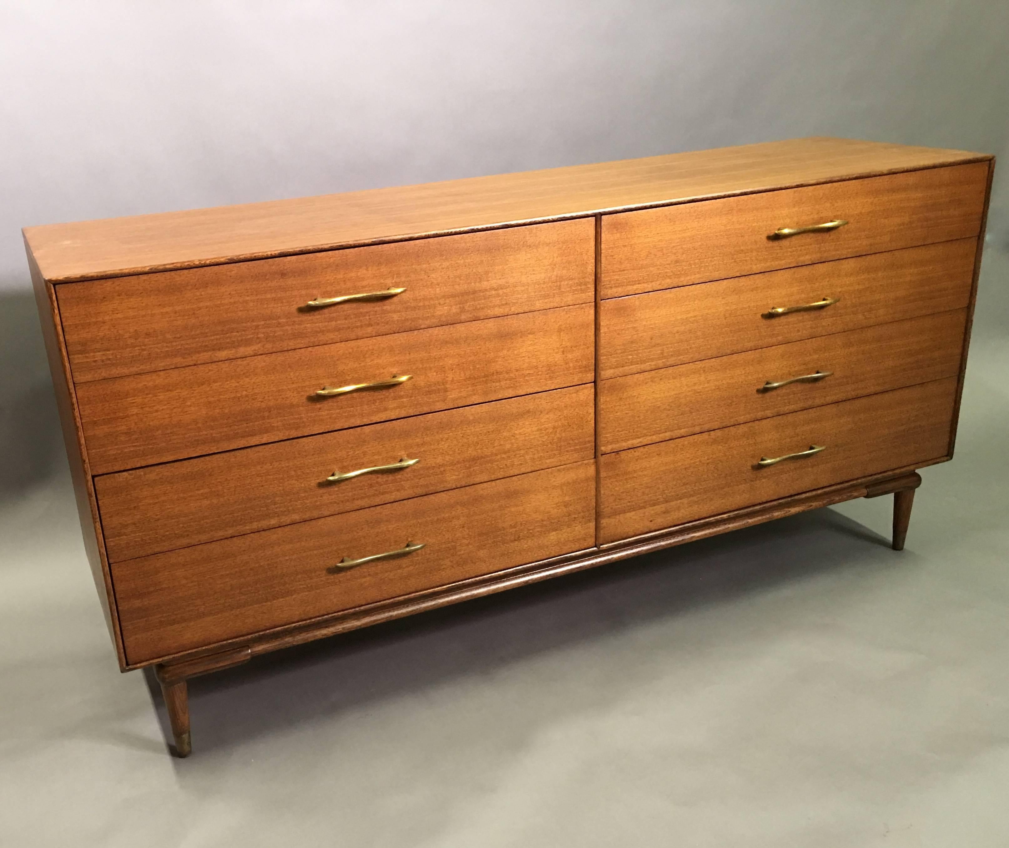 Nicely detailed, Mid-Century Modern, walnut, eight-drawer, double-wide dresser with decorative brass pulls and brass capped feet.